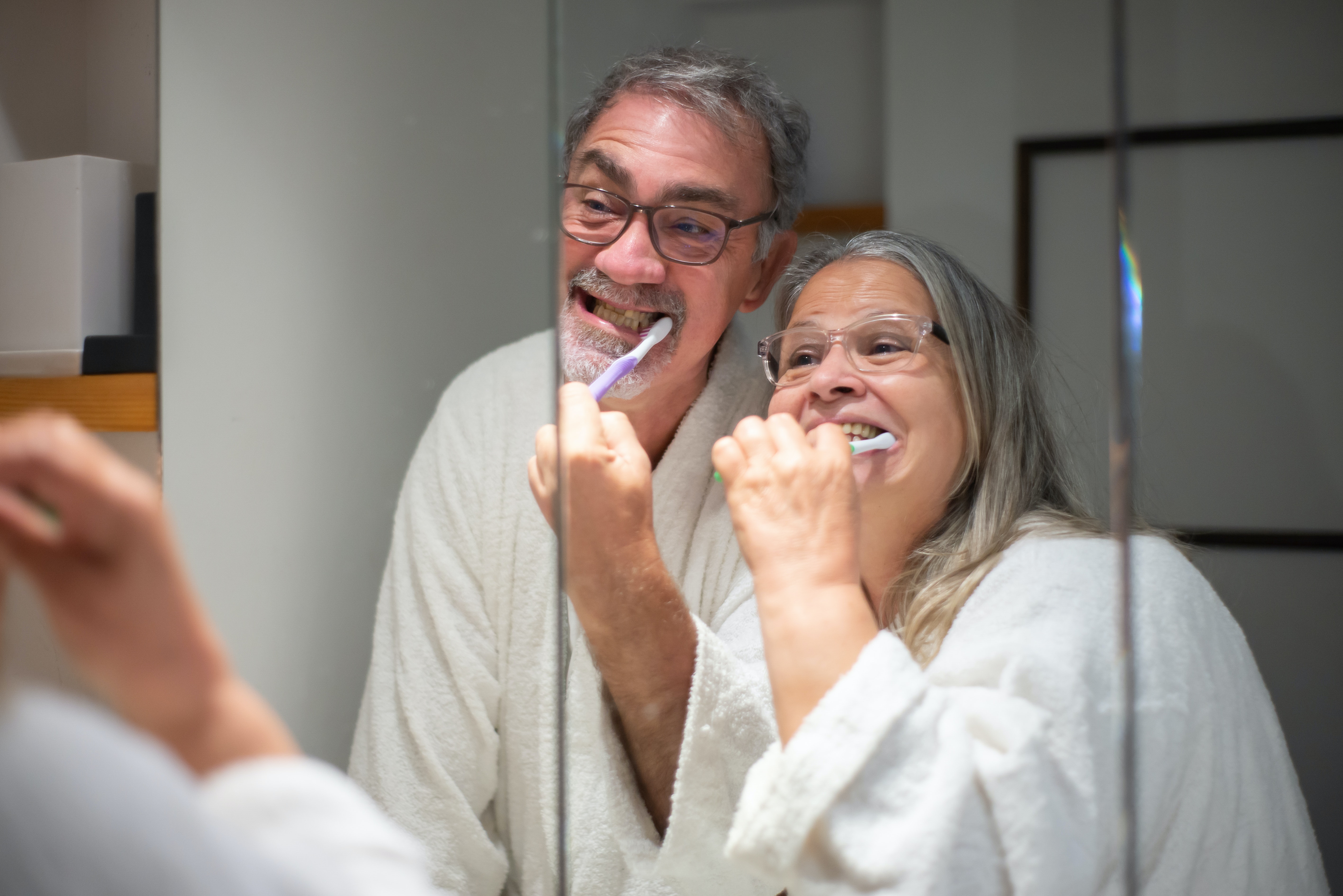 woman in white robe with cigarette stick on mouth