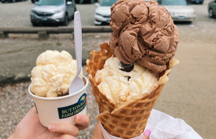 A cup and a waffle cone of ice cream outside in Connecticut.