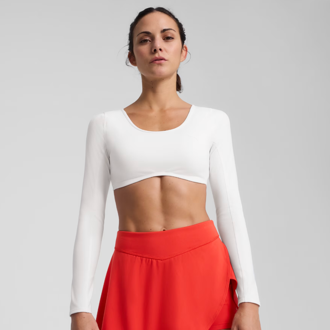 woman wearing a white cropped long sleeve shirt and red skirt