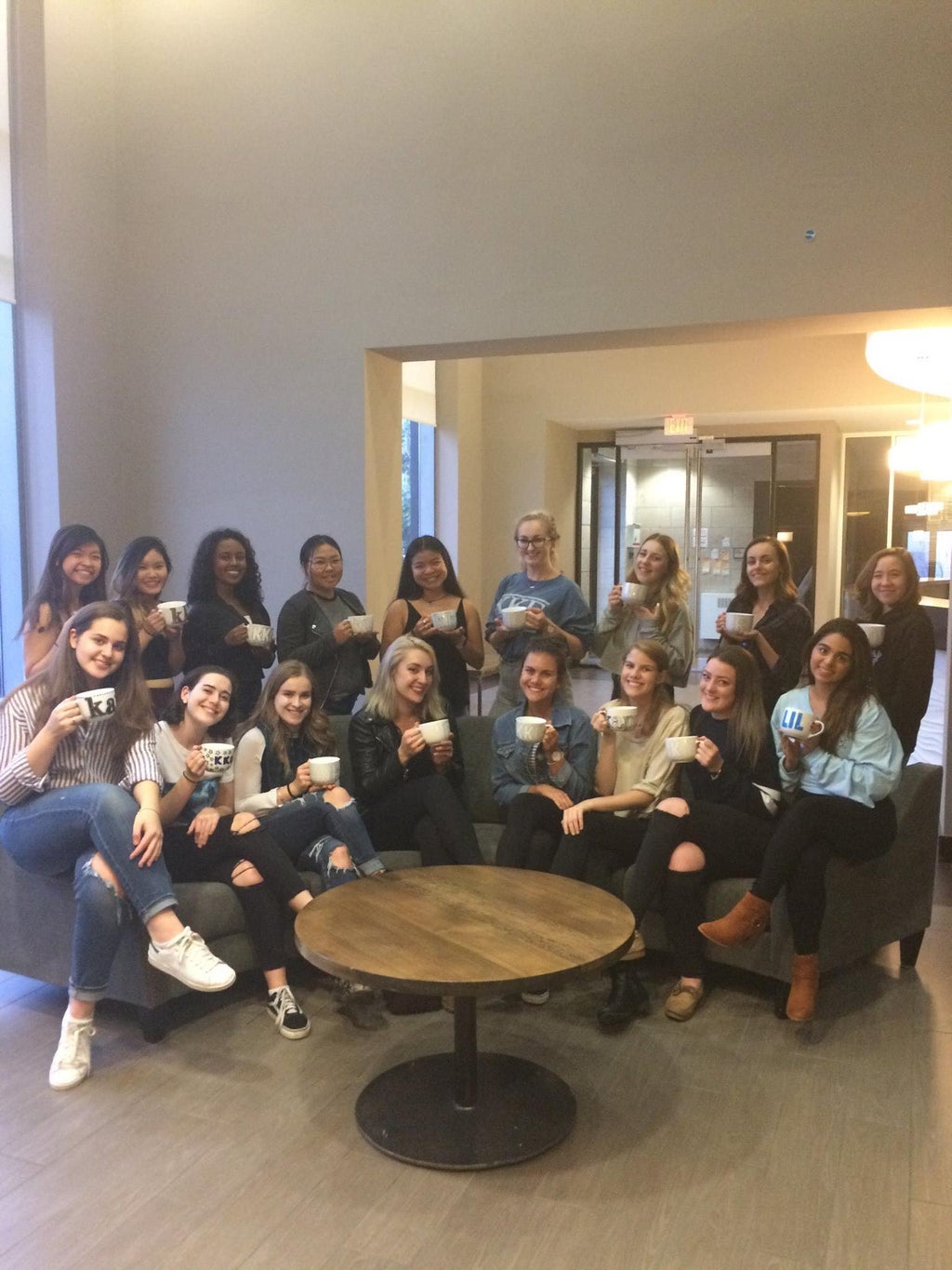 group of sorority sisters holding decorated mugs