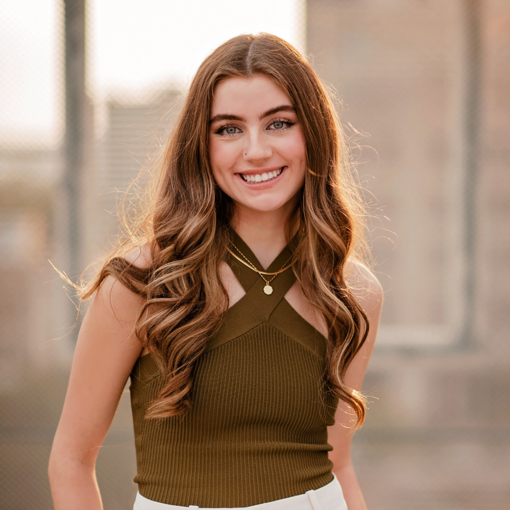 woman with light brown hair wearing a brown tank top