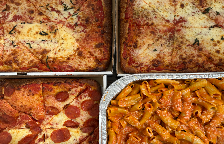 Close up of platters of pizza and pasta.