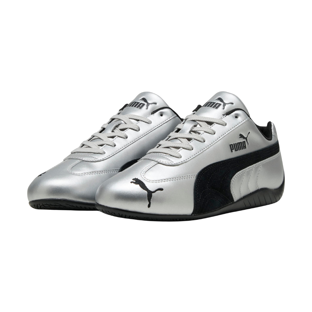 Silver athletic shoes with black detailing, featuring the PUMA logo on the side and toe. The sleek design conveys a modern, sporty feel.