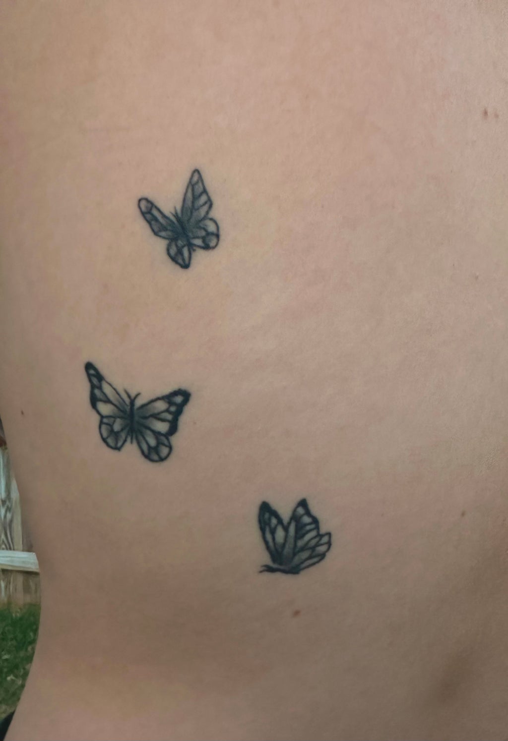 three butterflies tattoo on left side of back
