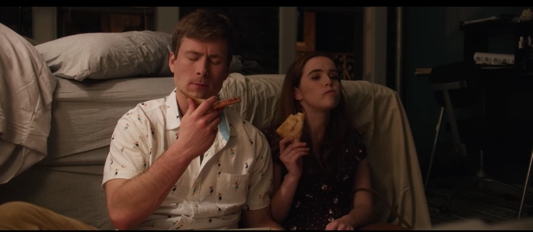 man and woman eating pizza