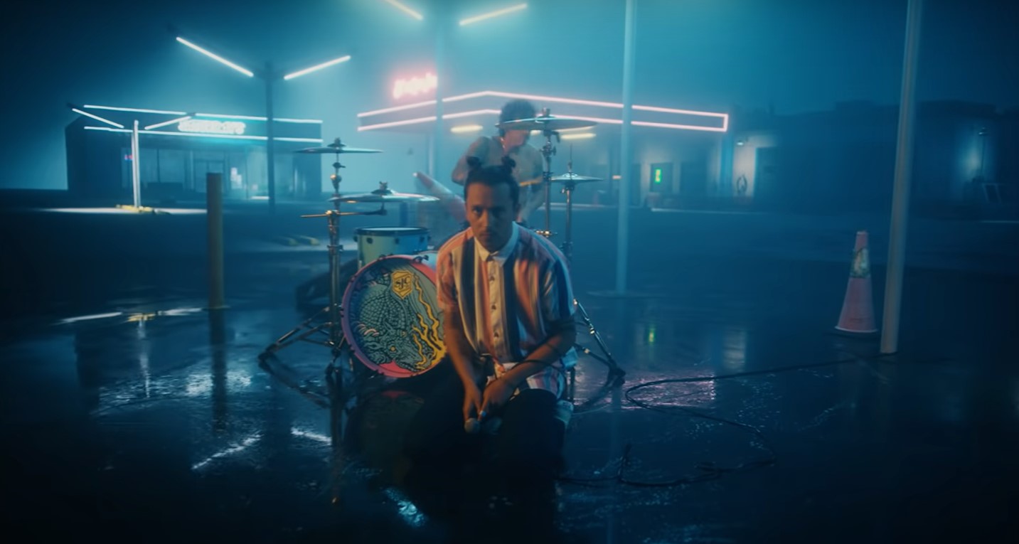 One man lowered down and another one playing drums in the back