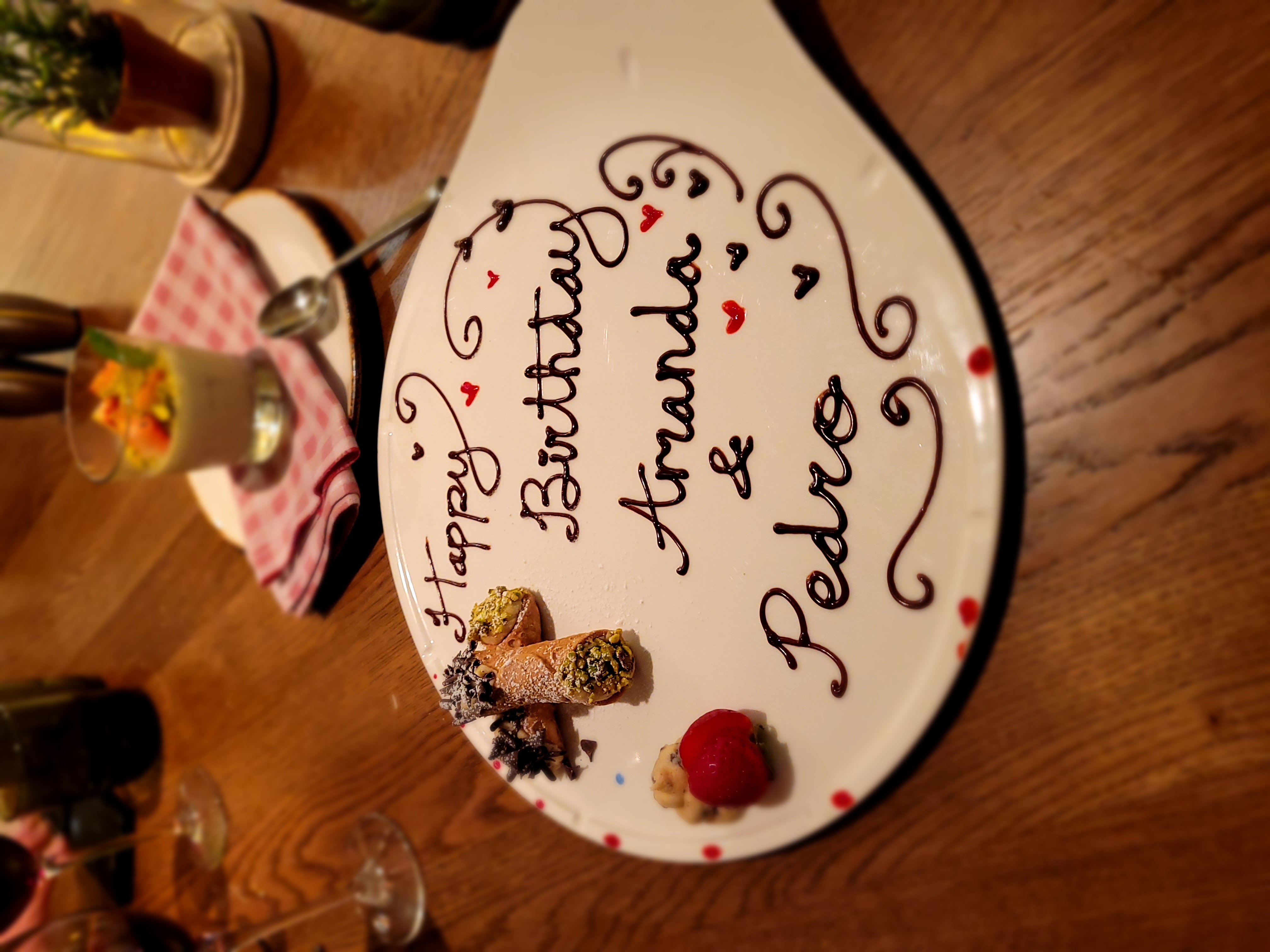 A dessert plate featuring handmade cannolis and chocolate text \