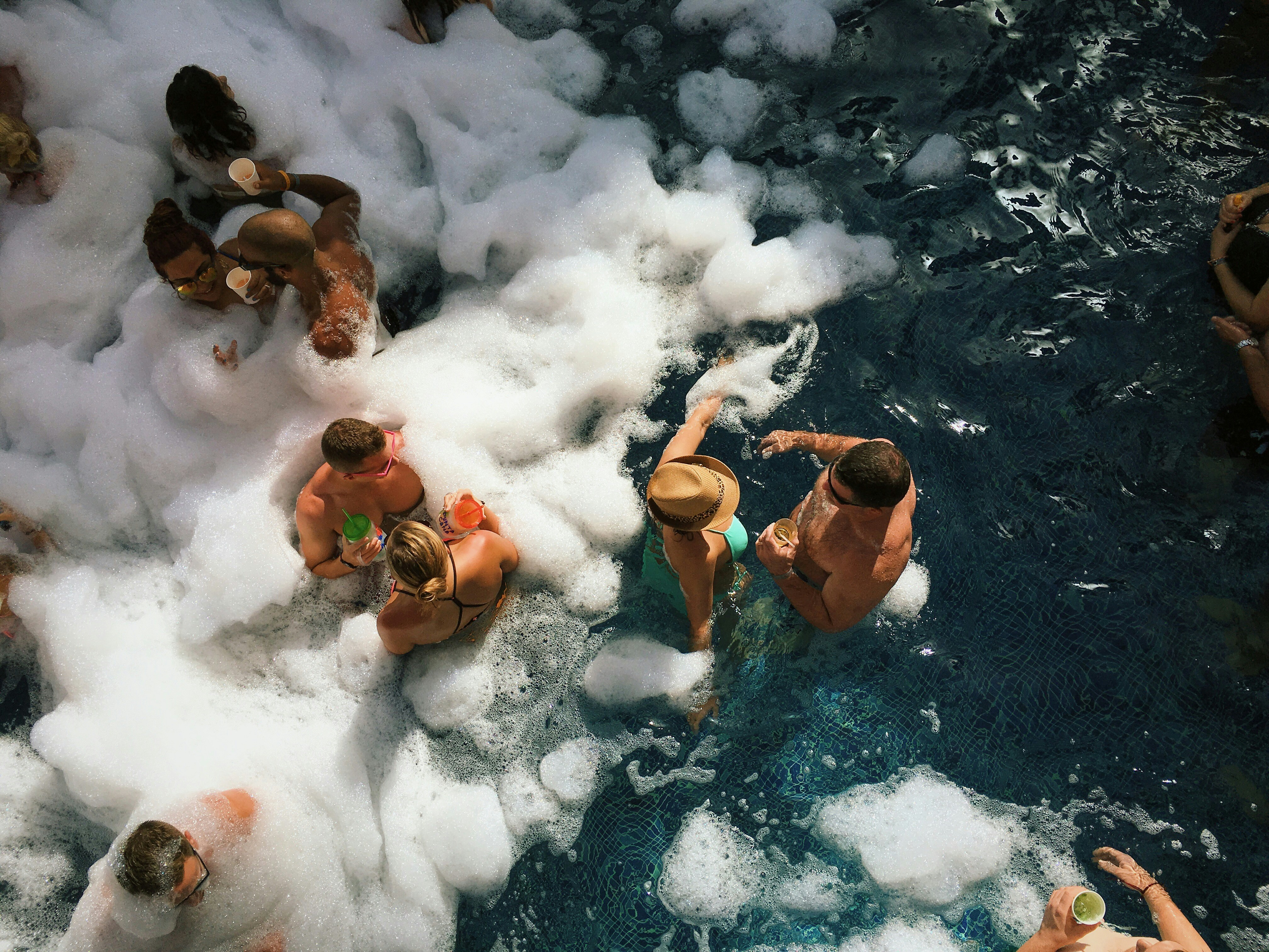 People in a pool holding drinks