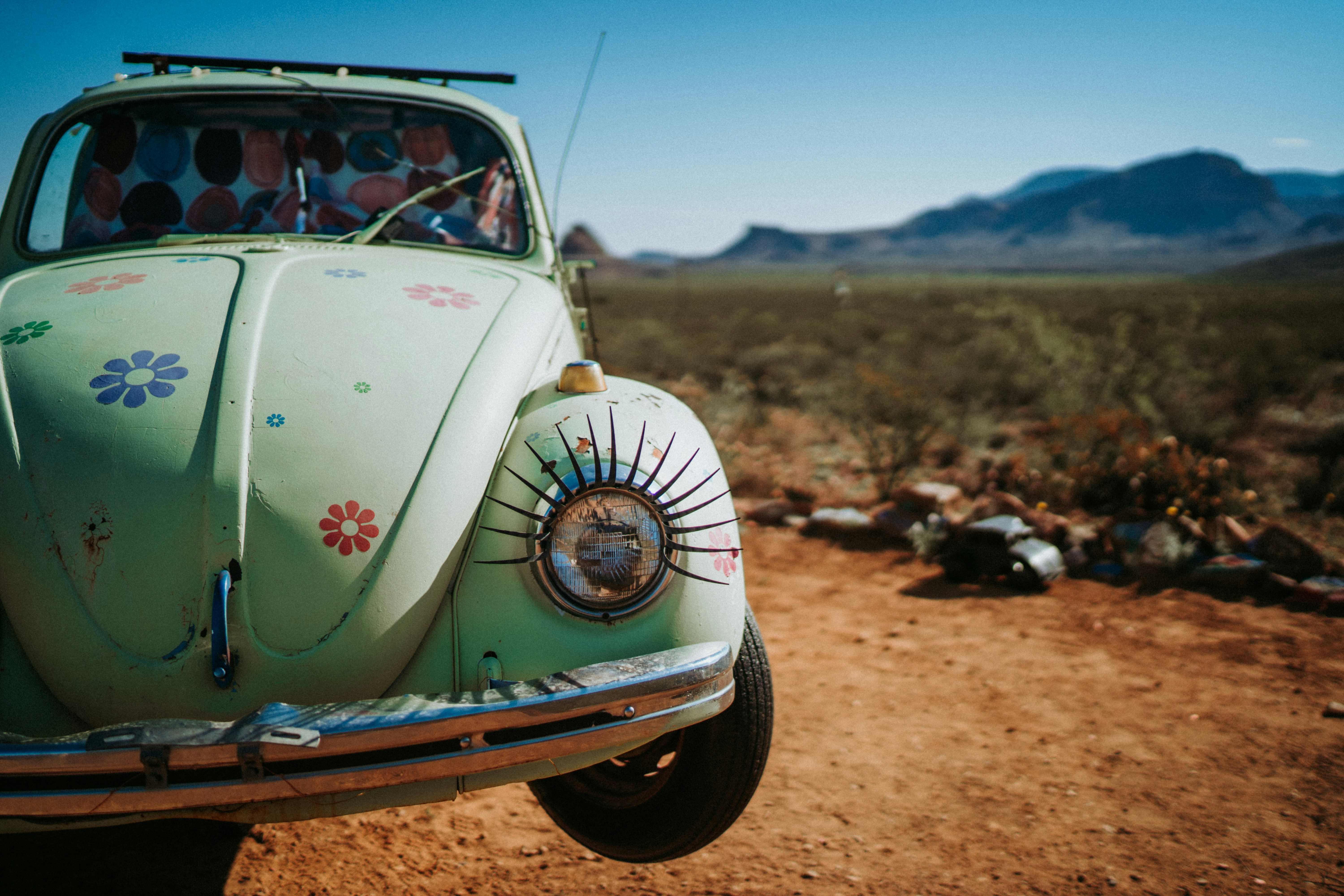 green car parked on a dirt road