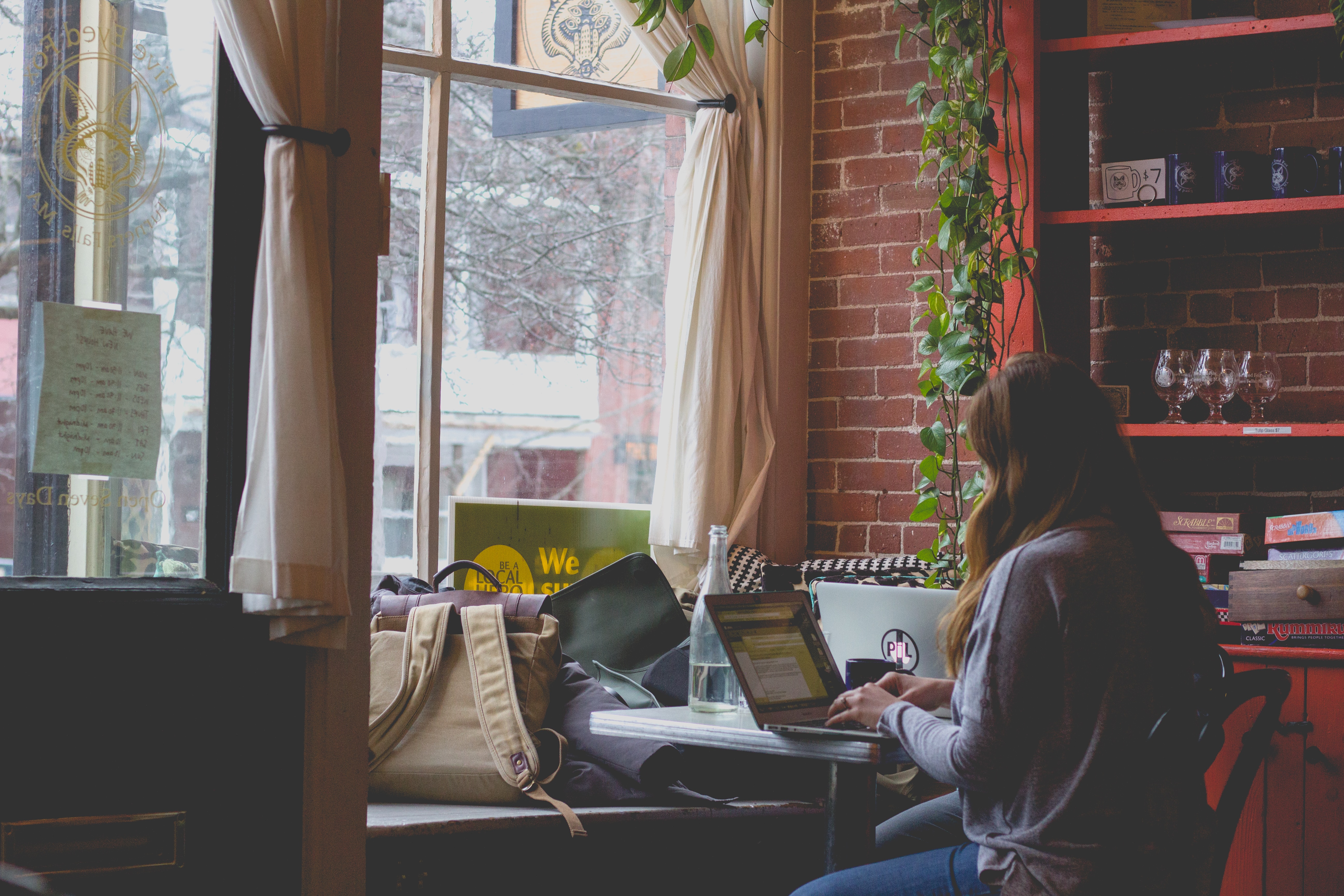 Girl doing work at a table by the window
