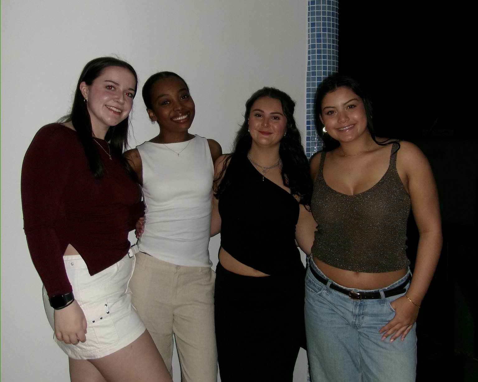 four girls standing together on a balcony
