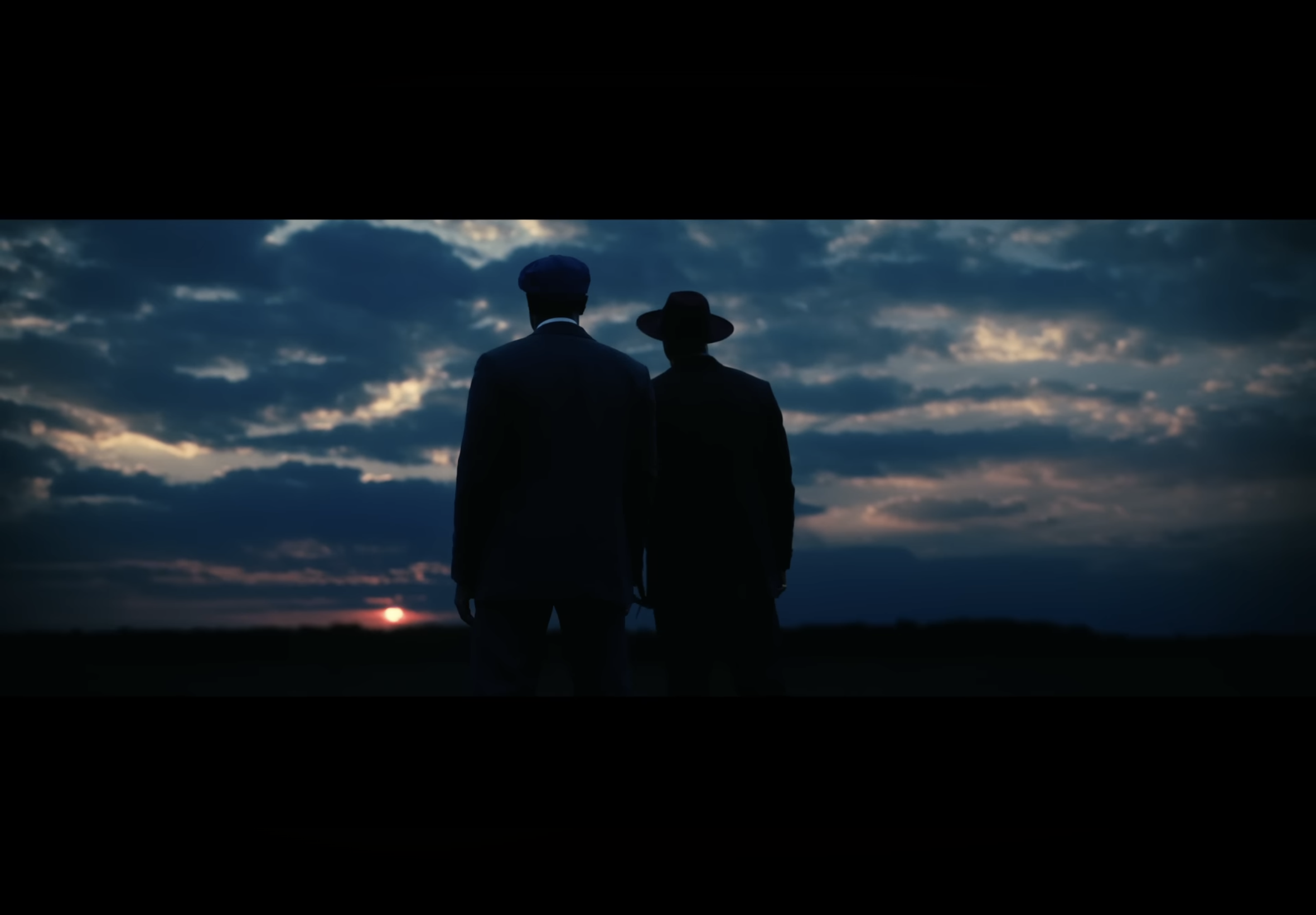 Two men standing and watching the sun set from the movie Sinners