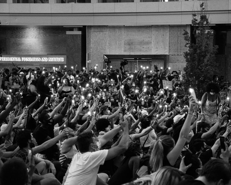 A black and white picture of a crowd at a Black Lives Matter protest in DC, 6/3/2020. Many people have their phones out with the flashes on, recording the events unfolding.