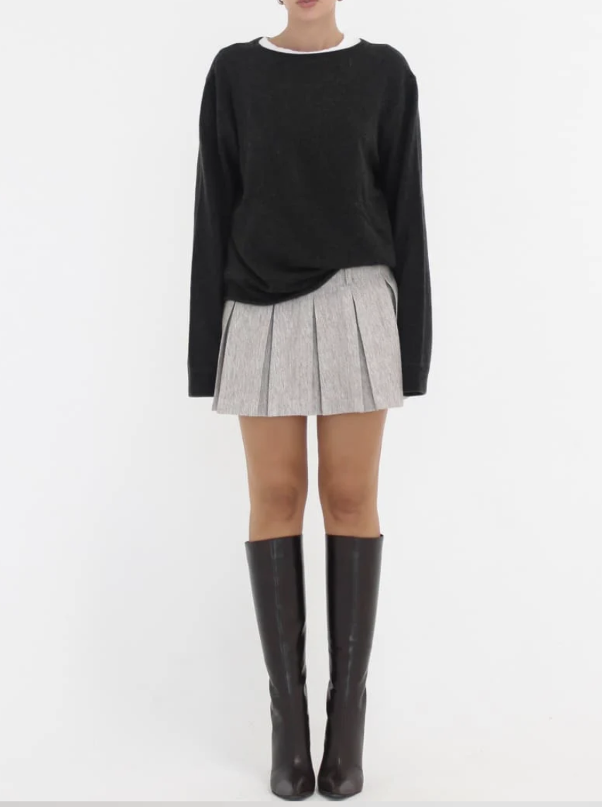 Black sweater and grey skirt outfit with tall black boots
