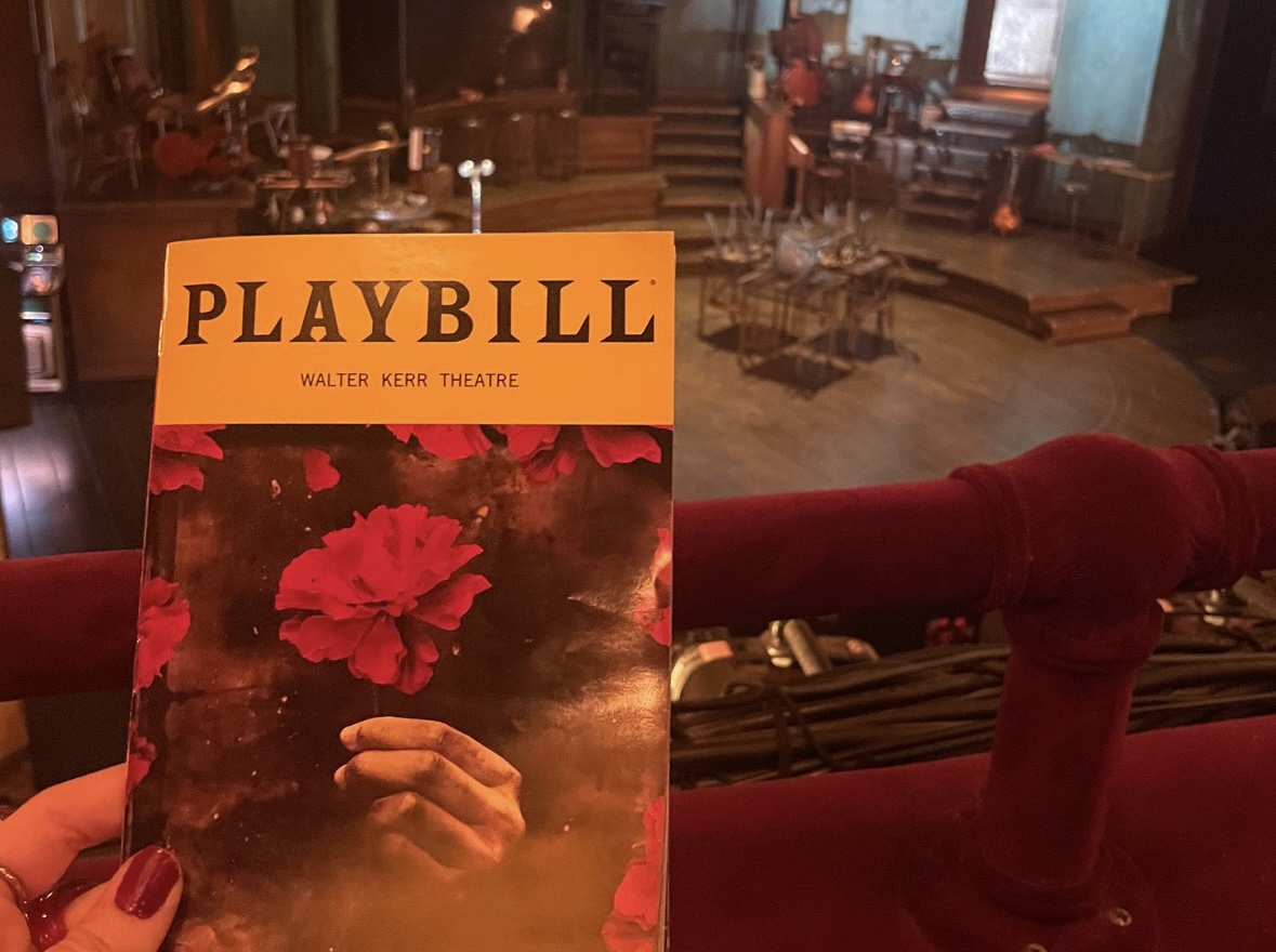 Playbill of Hadestown held infront of stage.