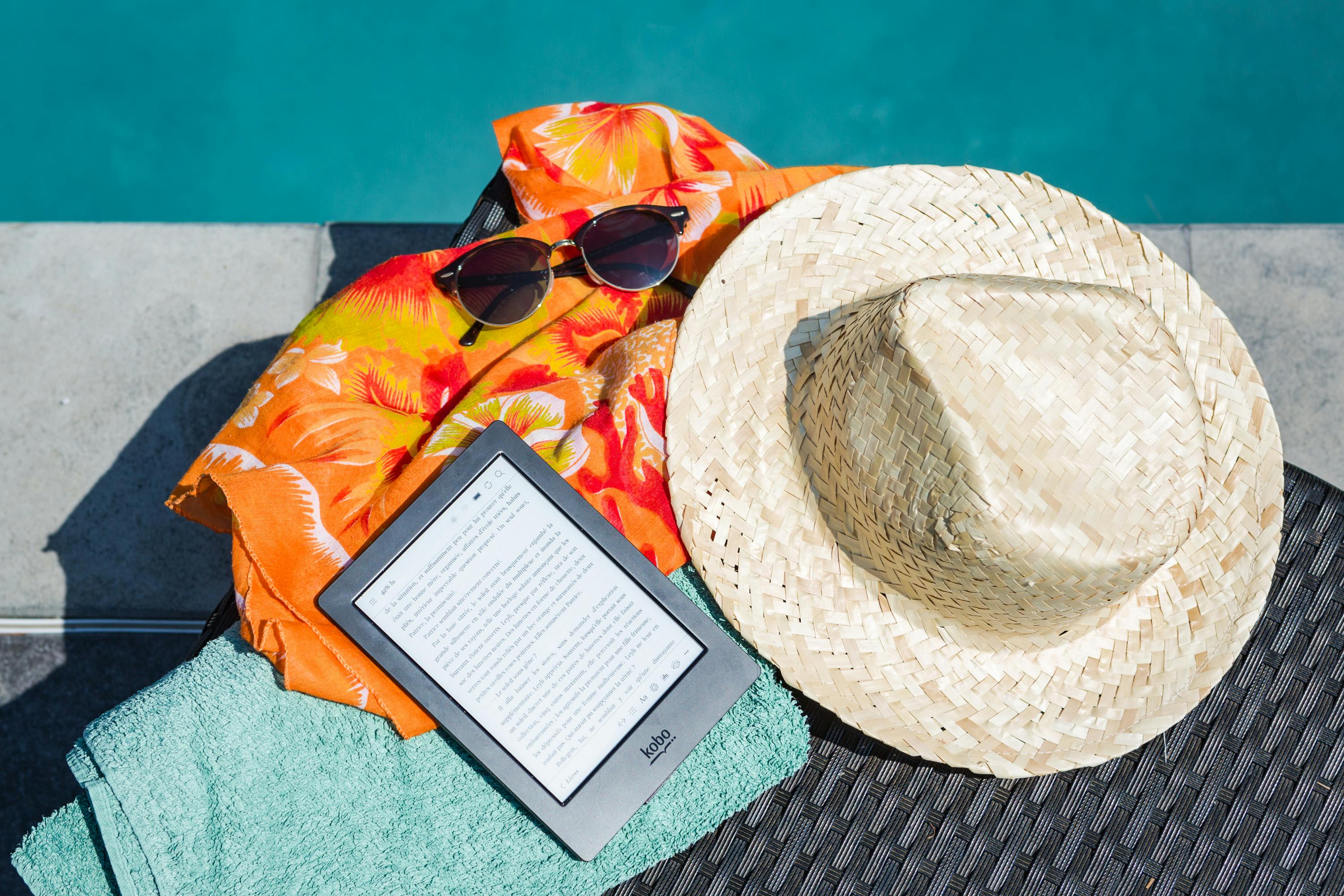 Hat, book and sunglasses by the pool
