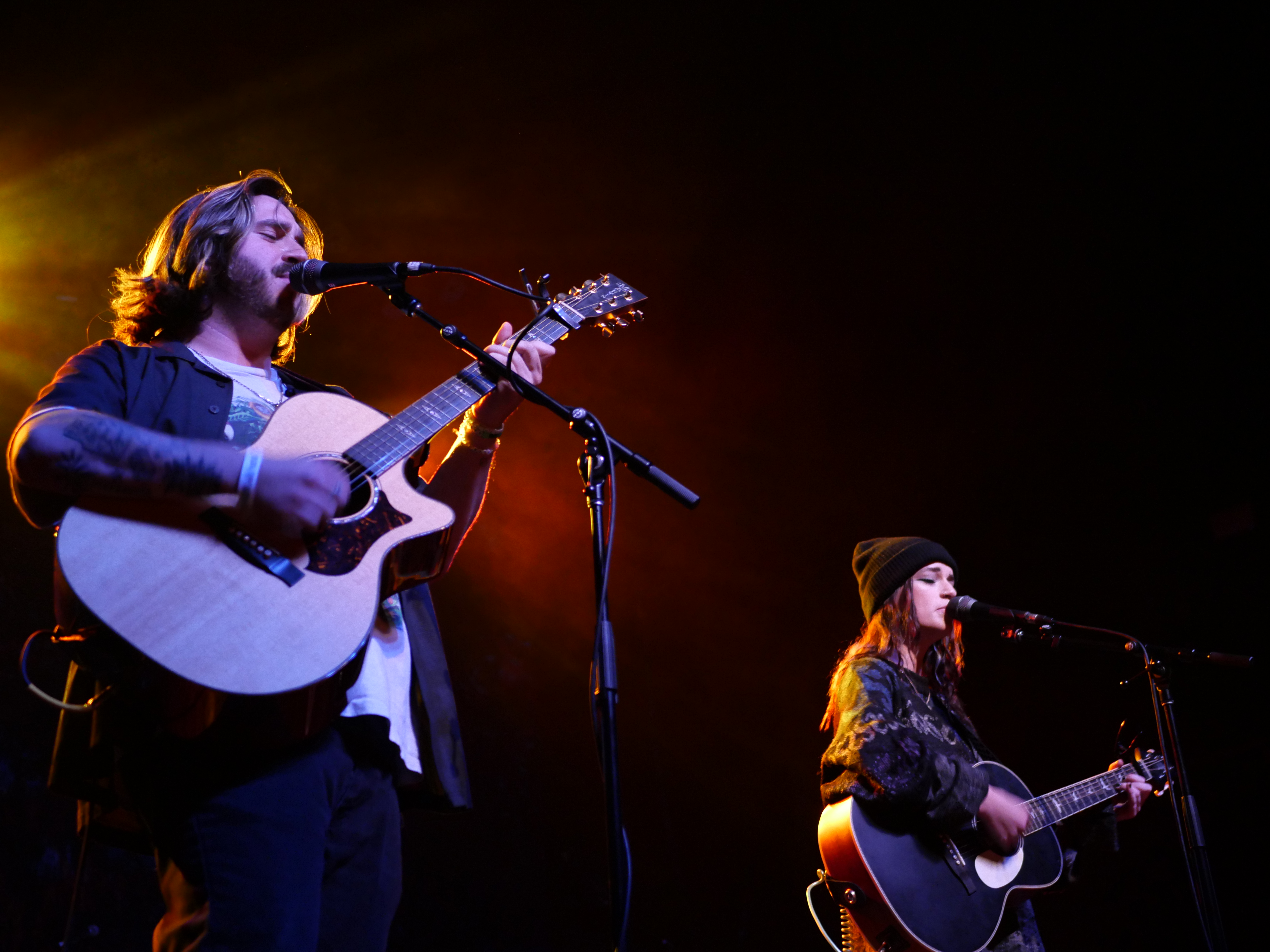 Man and woman playing guitar on stage