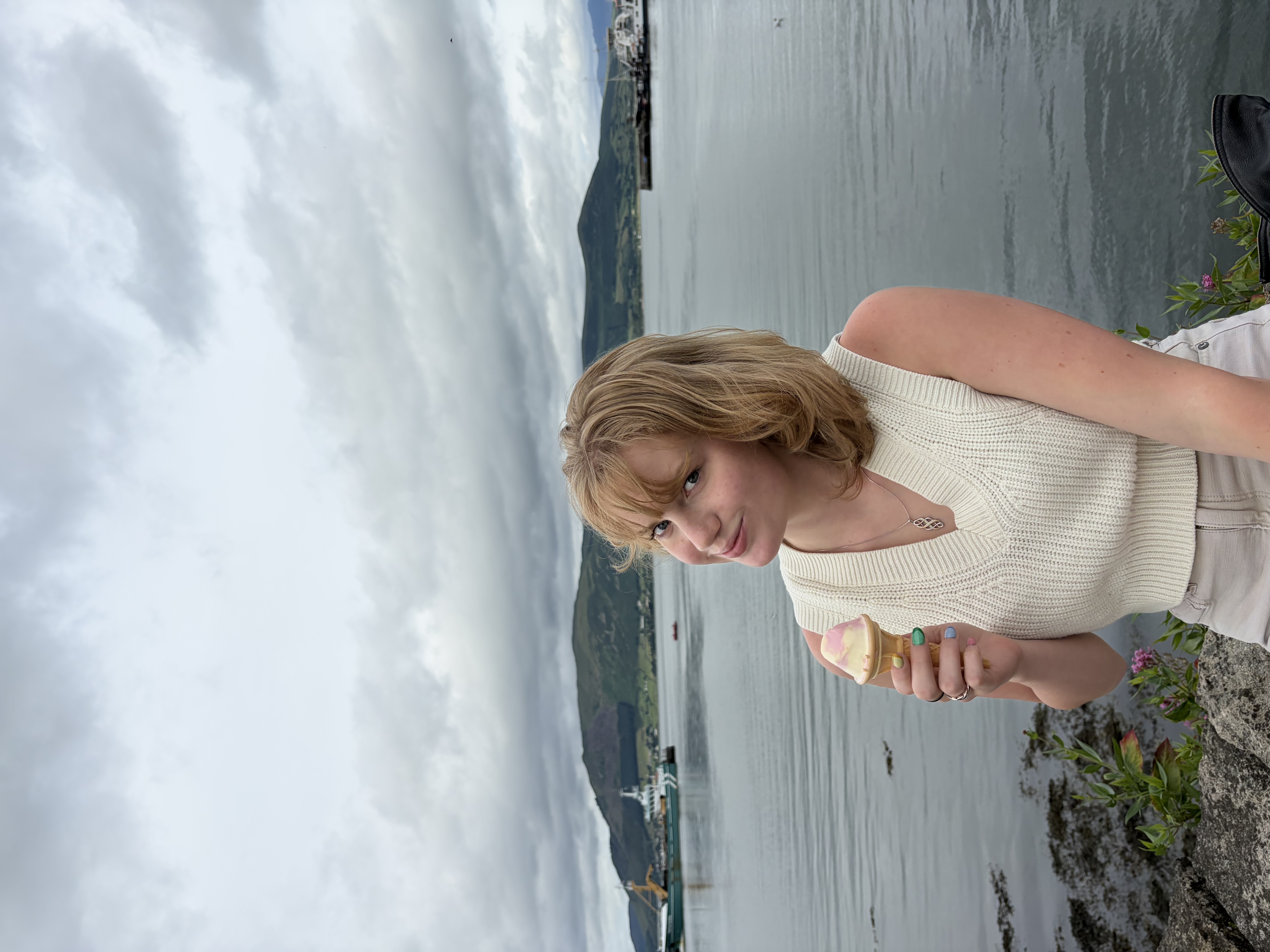 Girl holding ice cream in front of water