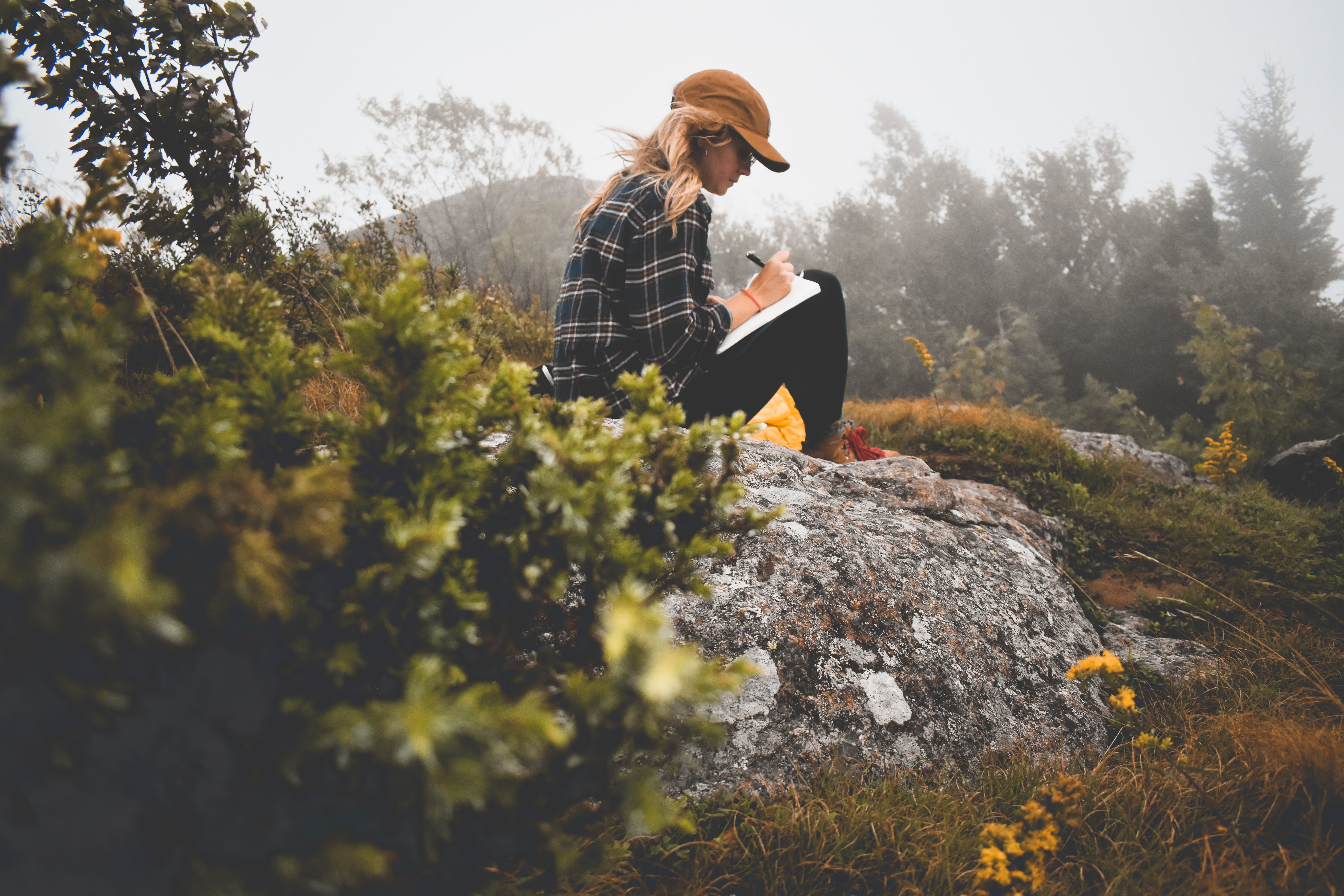 Girl journaling on rock