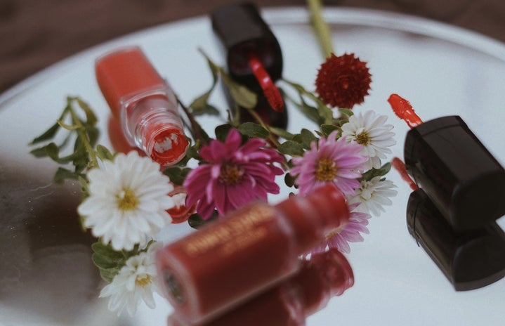 Makeup products surrounded by flowers.