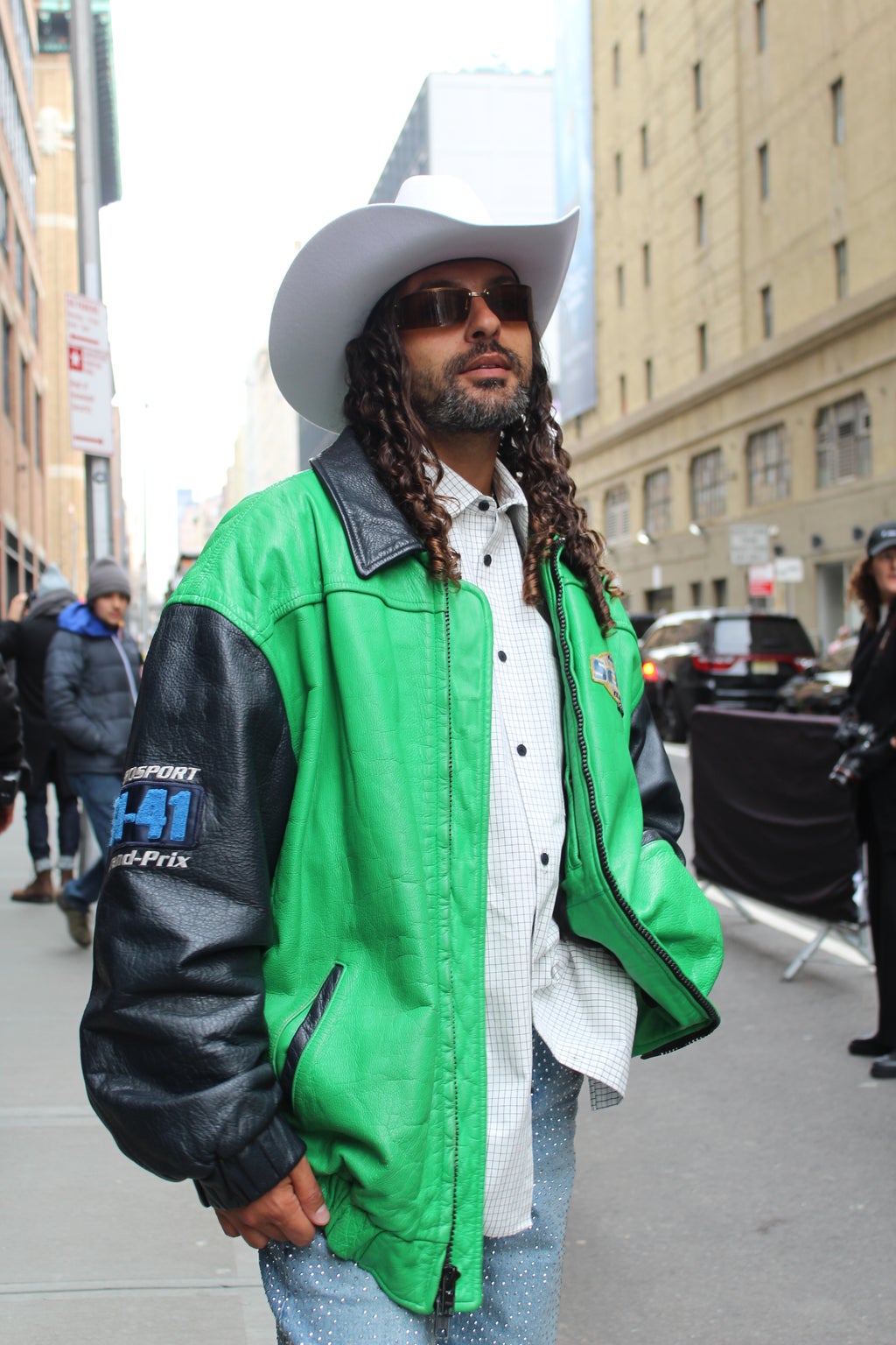 Man in vintage green and black jacket, cowboy hat, and jeans