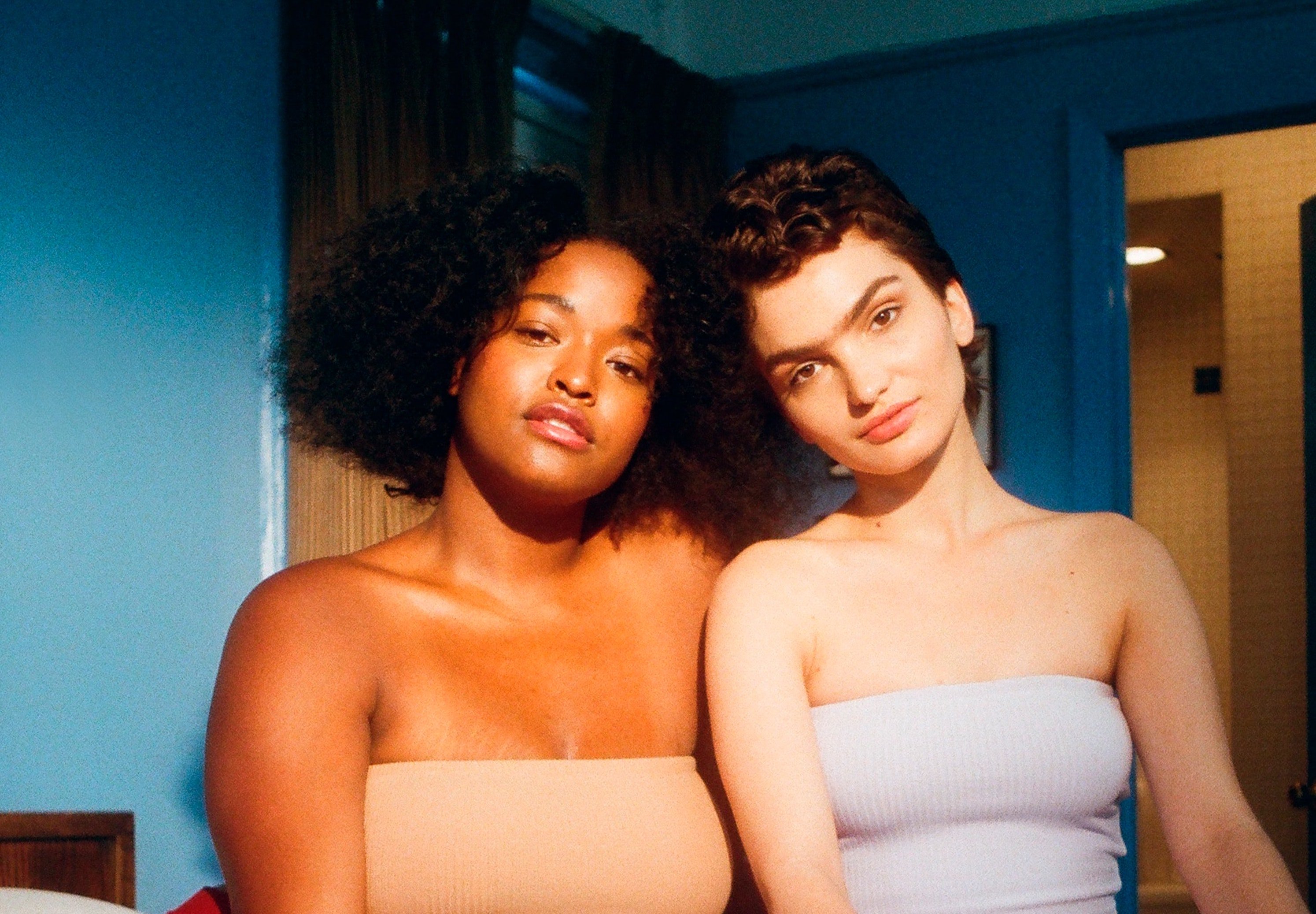 sitting side by side on bed