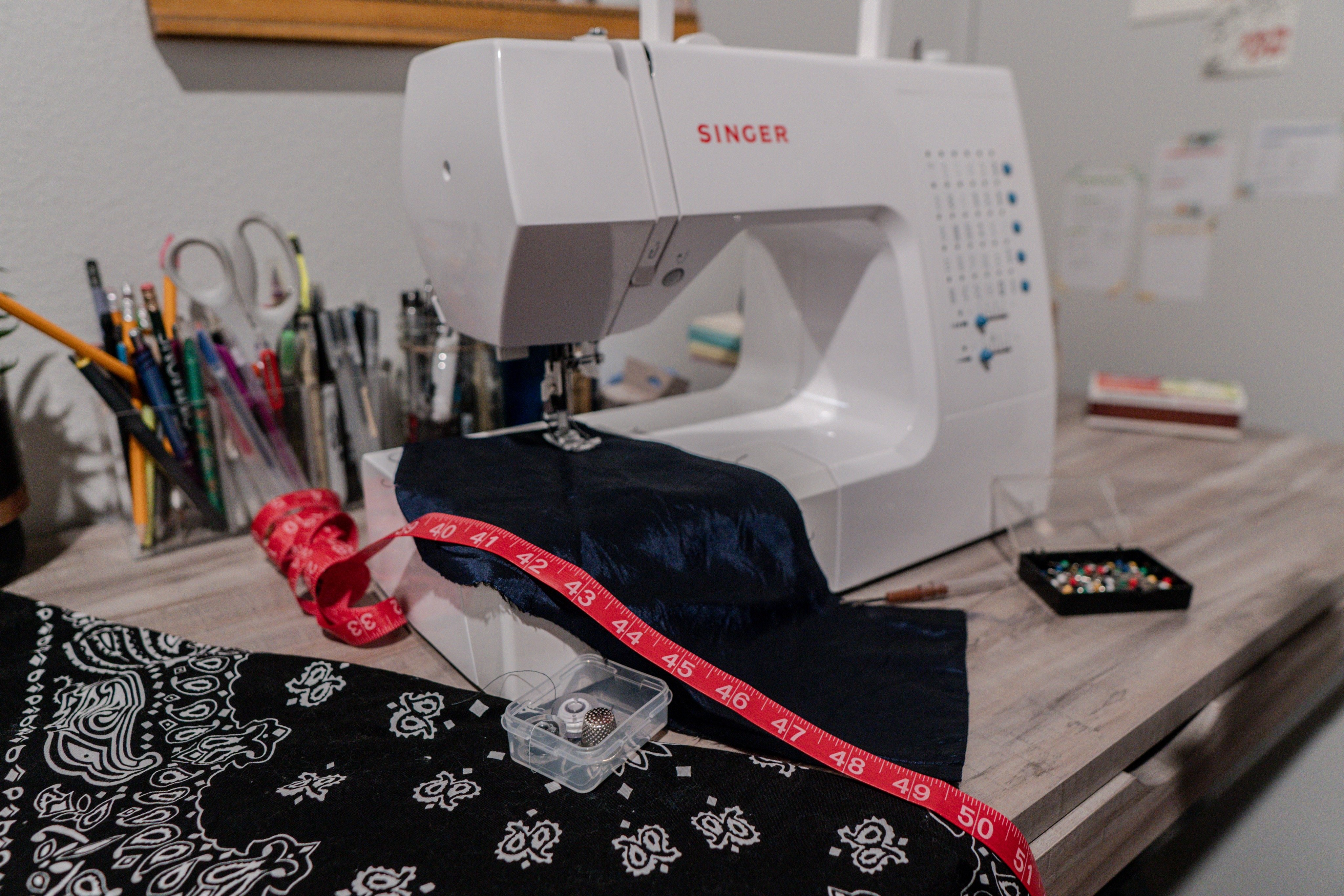sewing machine with pink measuring tape and blue fabric