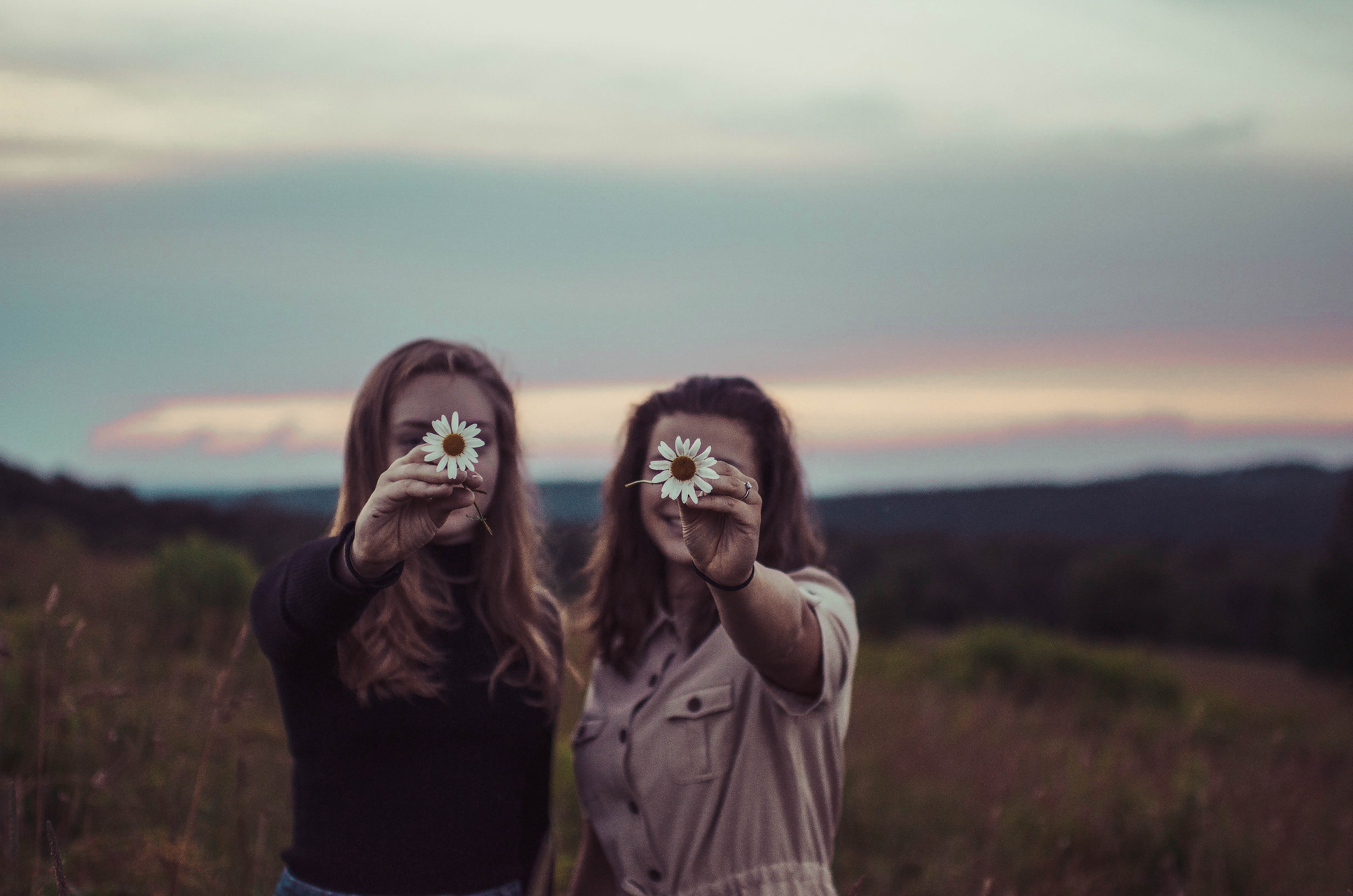 best friends holding flowers by Sam Manns from Unsplash