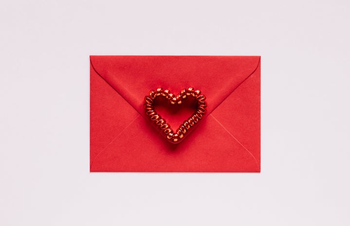 Red envelope with heart on pink background