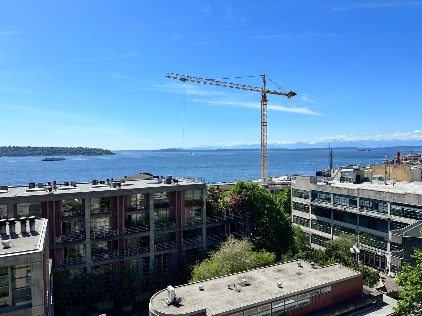 View of water, buildings, and mountains from rooftop in Seattle, Washington.