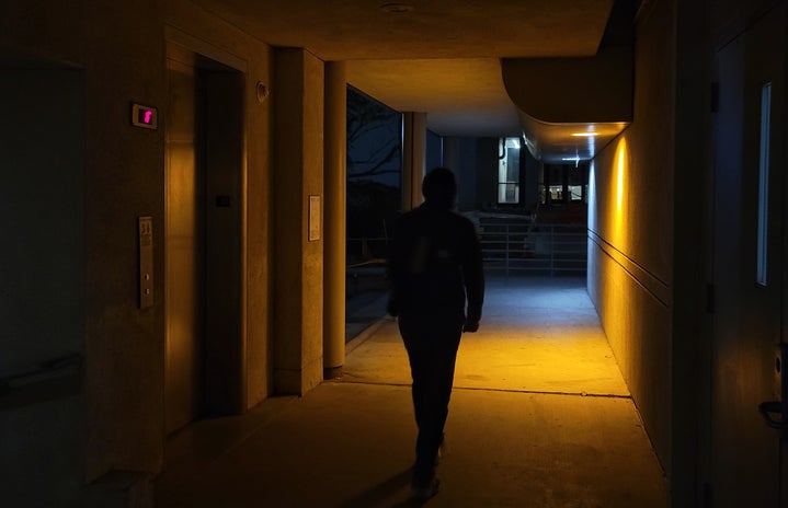 person exiting dimly lit hallway