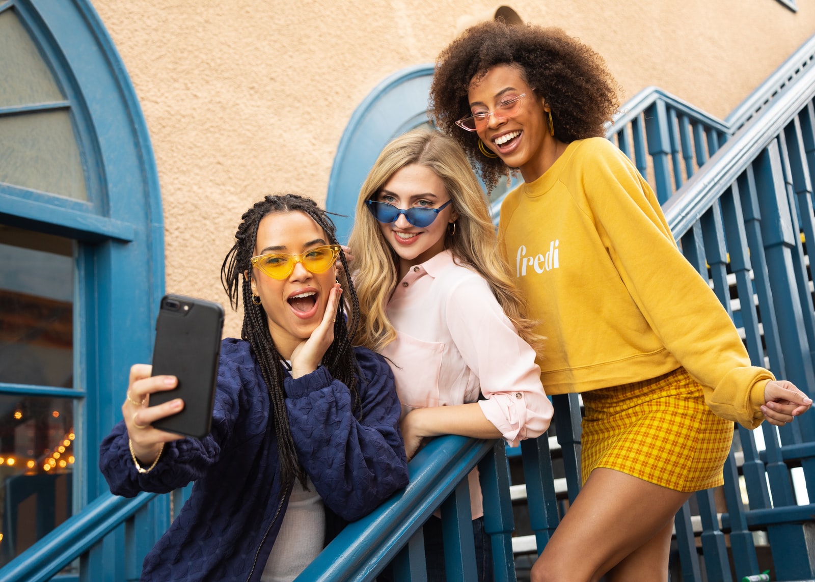 group of teenagers smiling at a cell phone