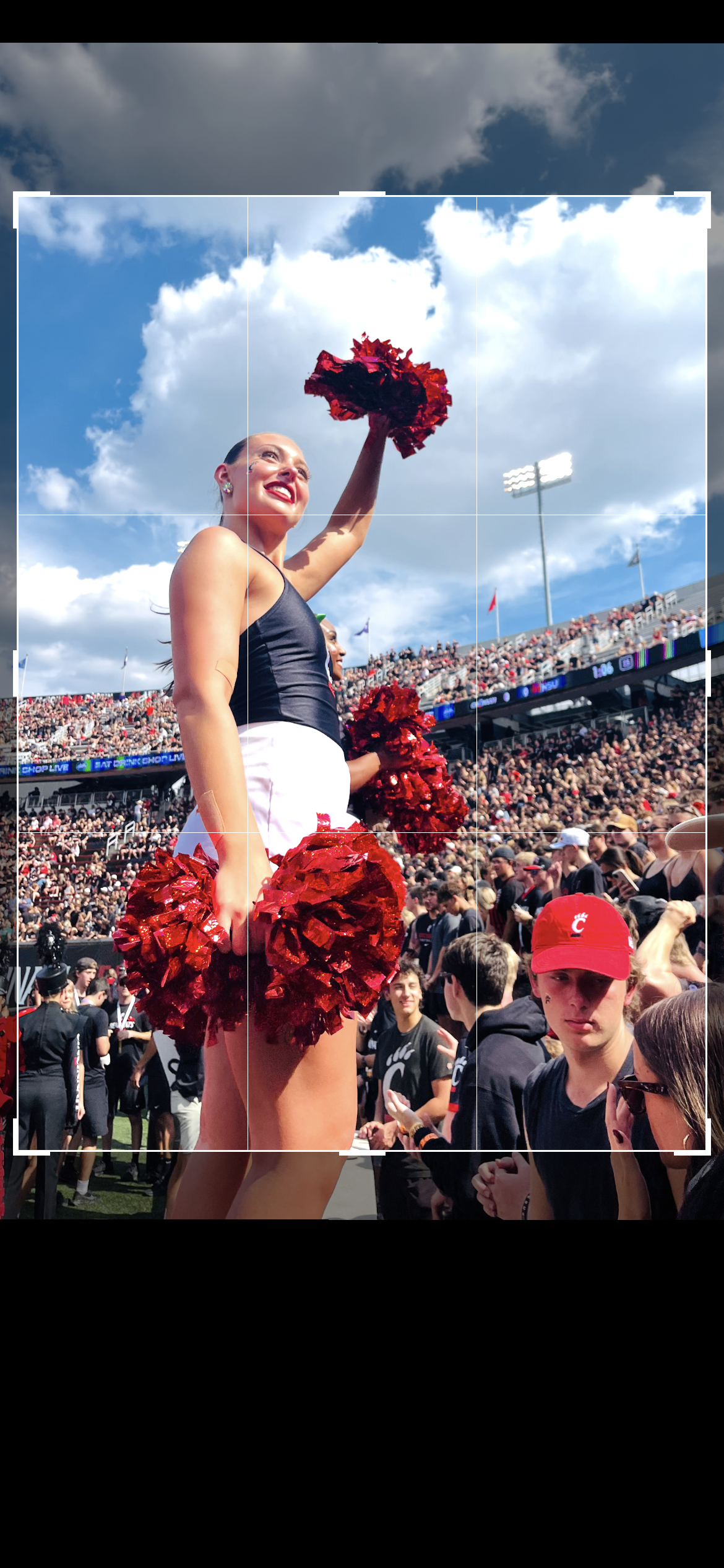 A cheerleader in a stunt during a football game with the camera grid on top of it demonstrating a crop in the \