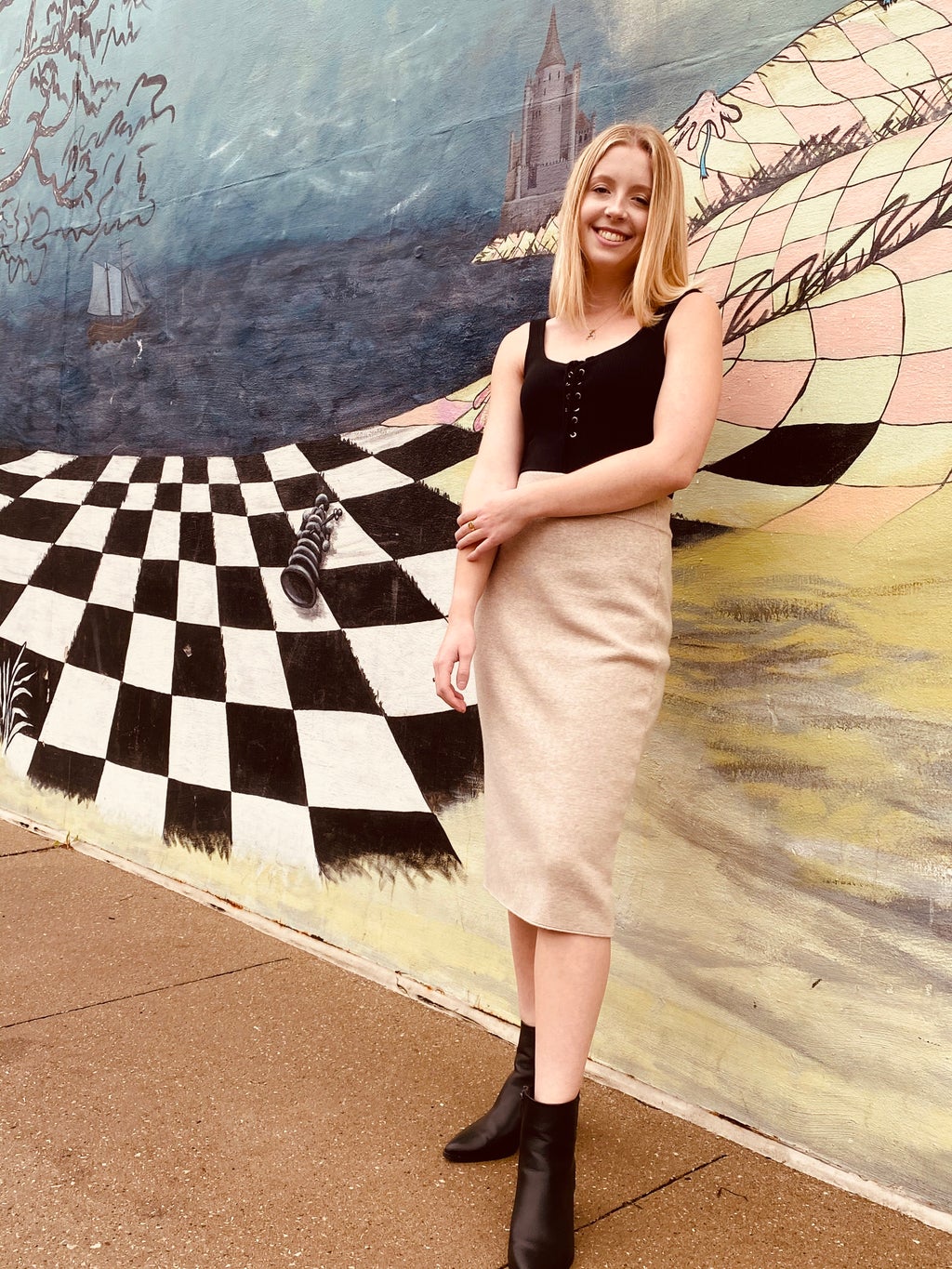 girl in midi skirt in front of checkered mural