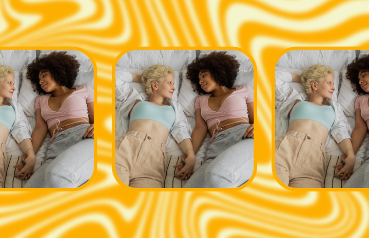 two women holding hands in bed