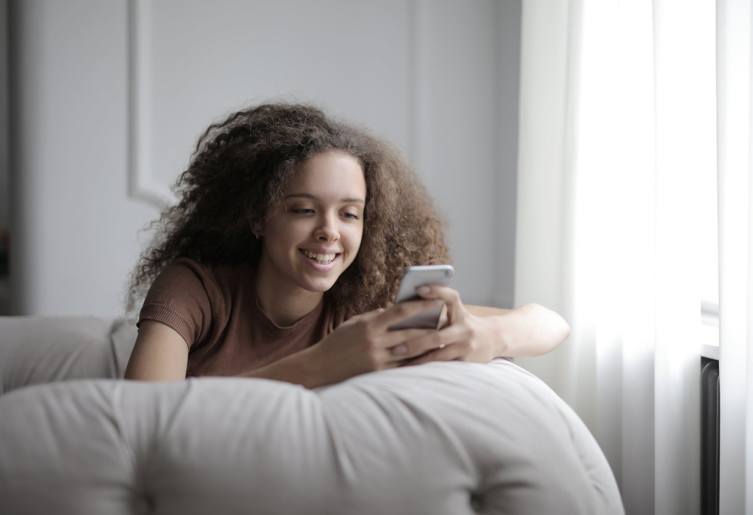 young woman holding phone on couch