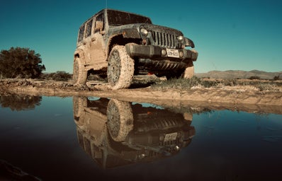 A dirty jeep and a body of water