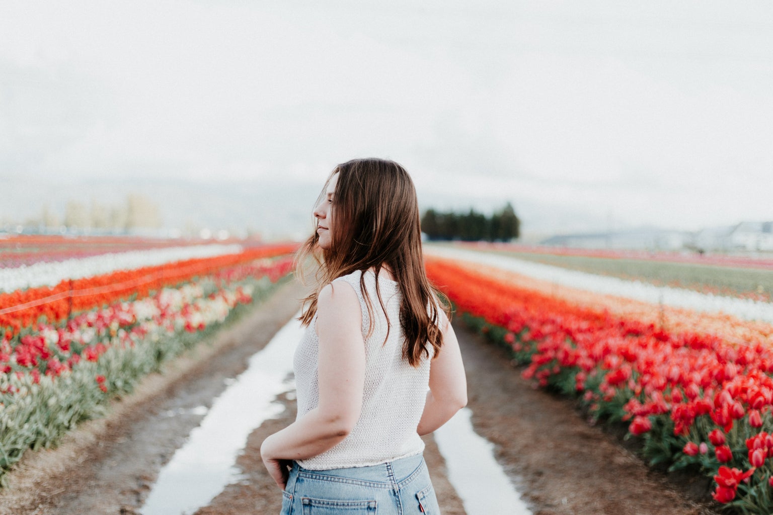 girl standing in field of flowers