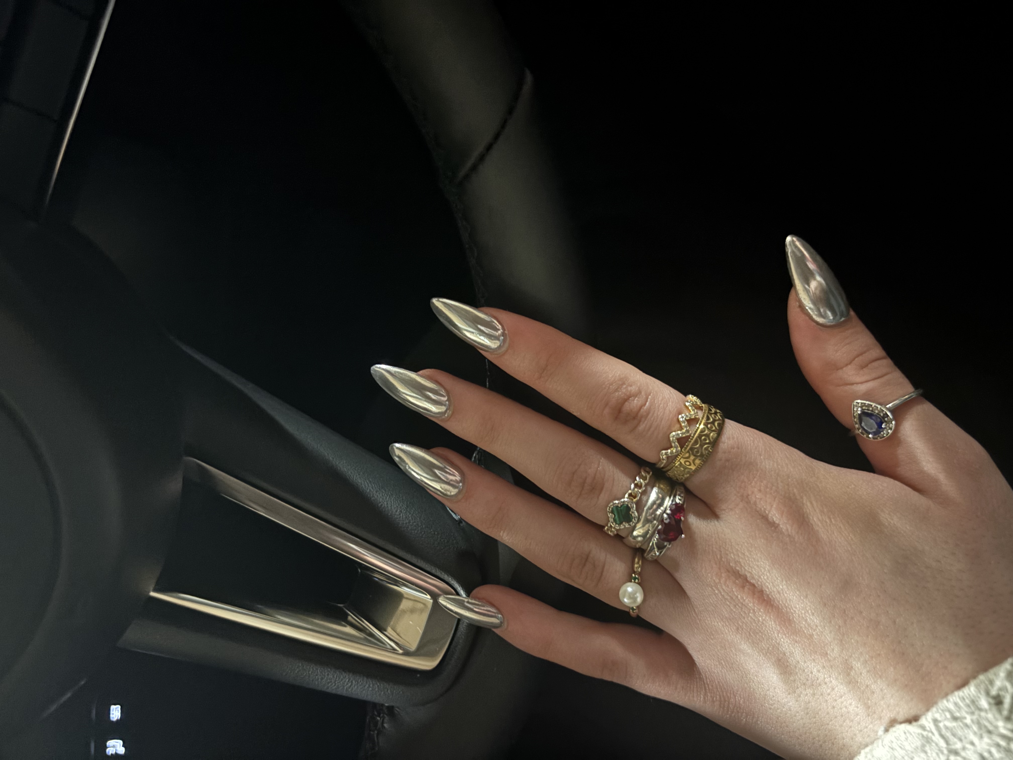 Hand with silver nails and various rings