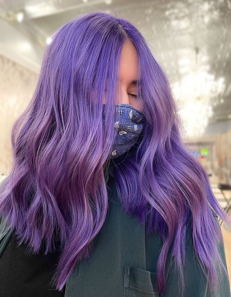 Girl with purple hair color in salon chair.