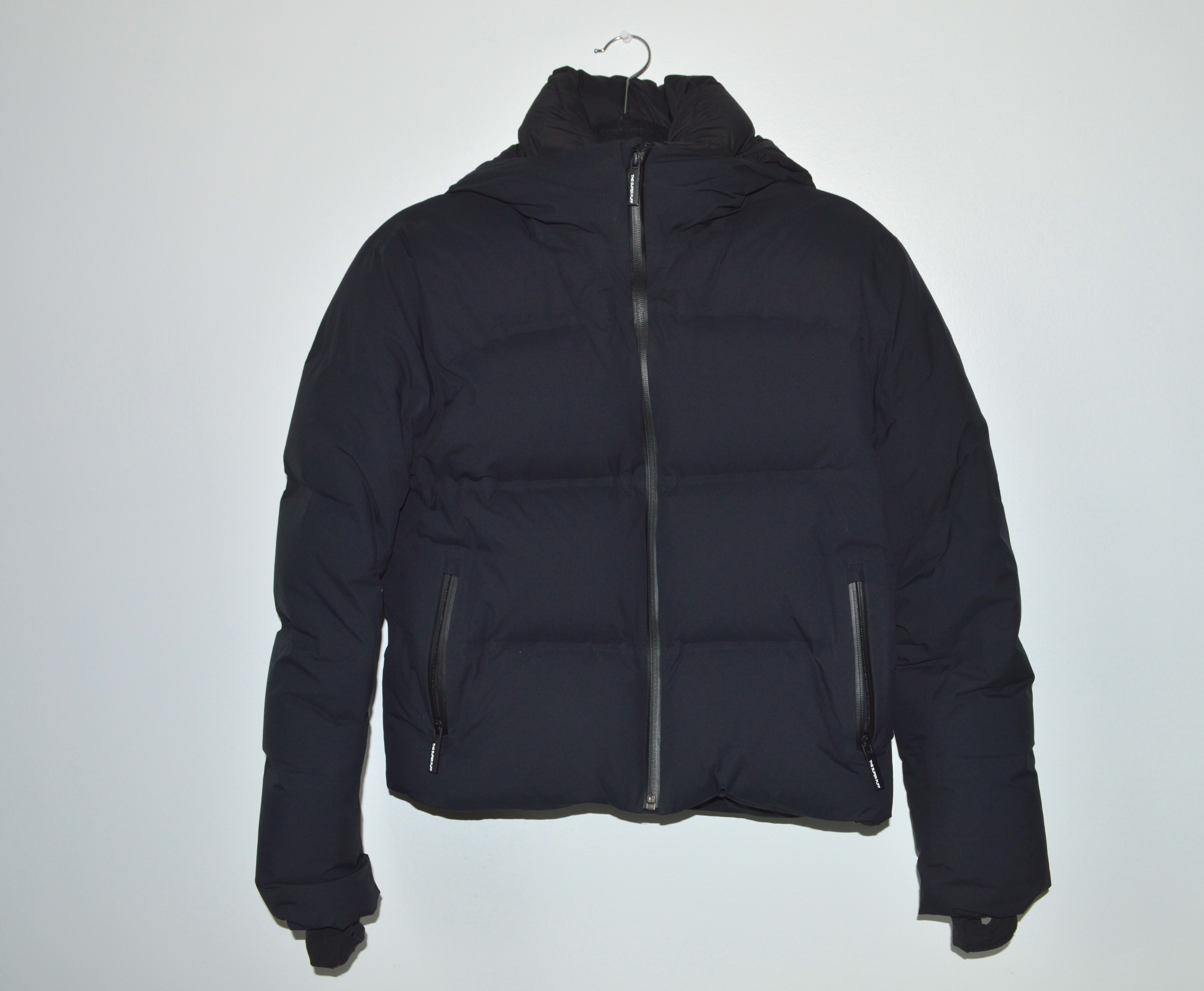 black aritzia puffer jacket on clear background