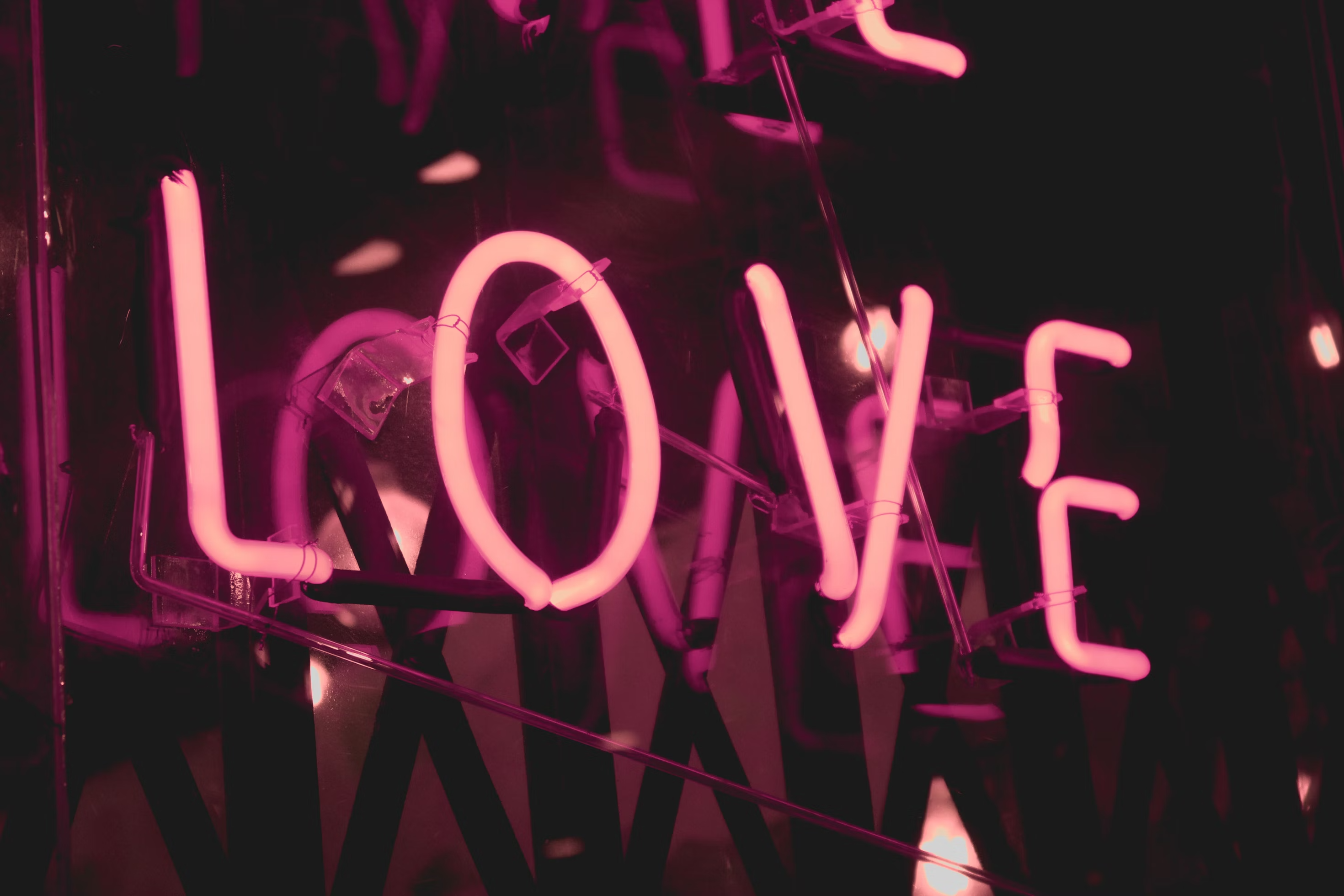 A pink neon sign that says \"Love\"