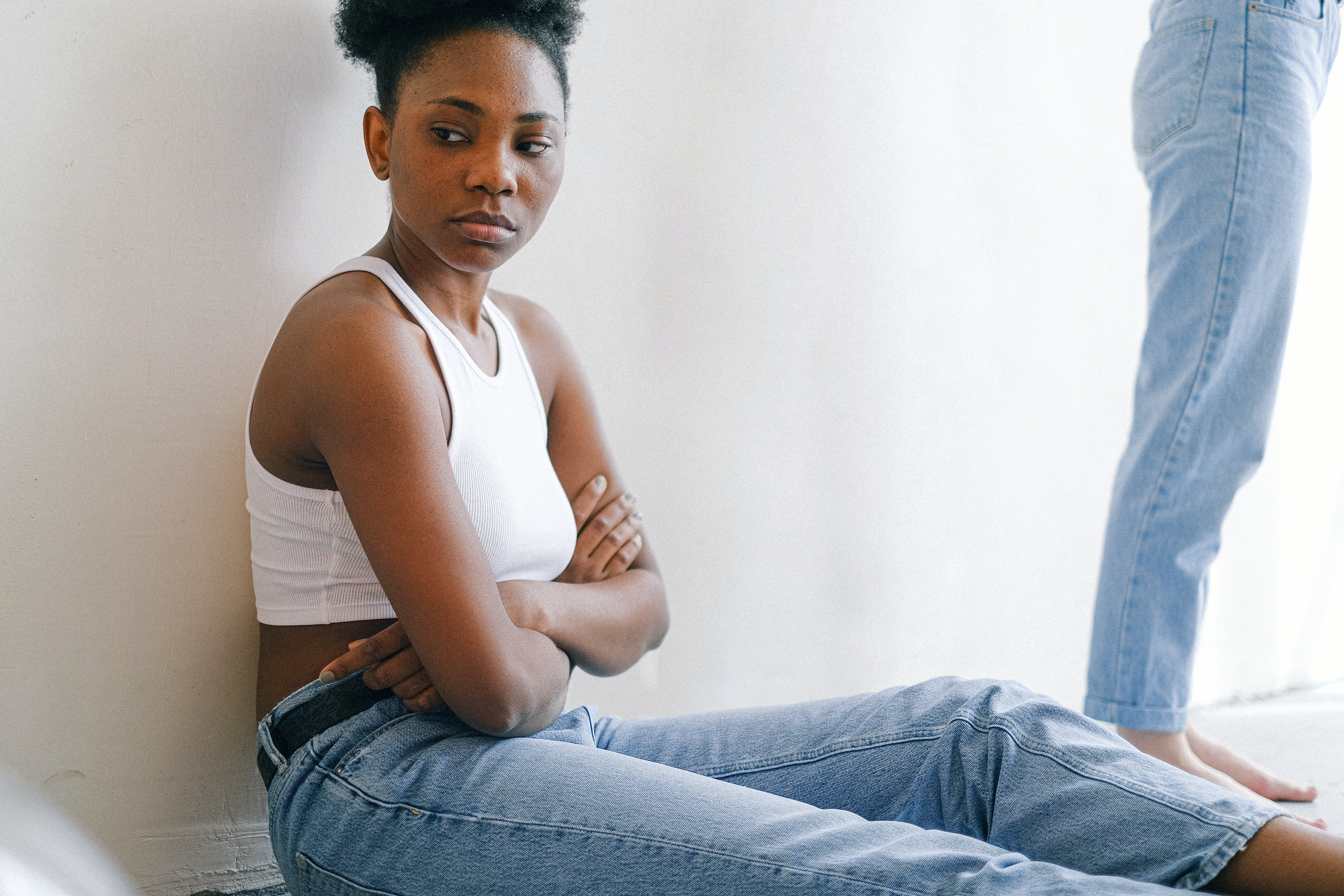 upset woman sitting on the floor with arms crossed