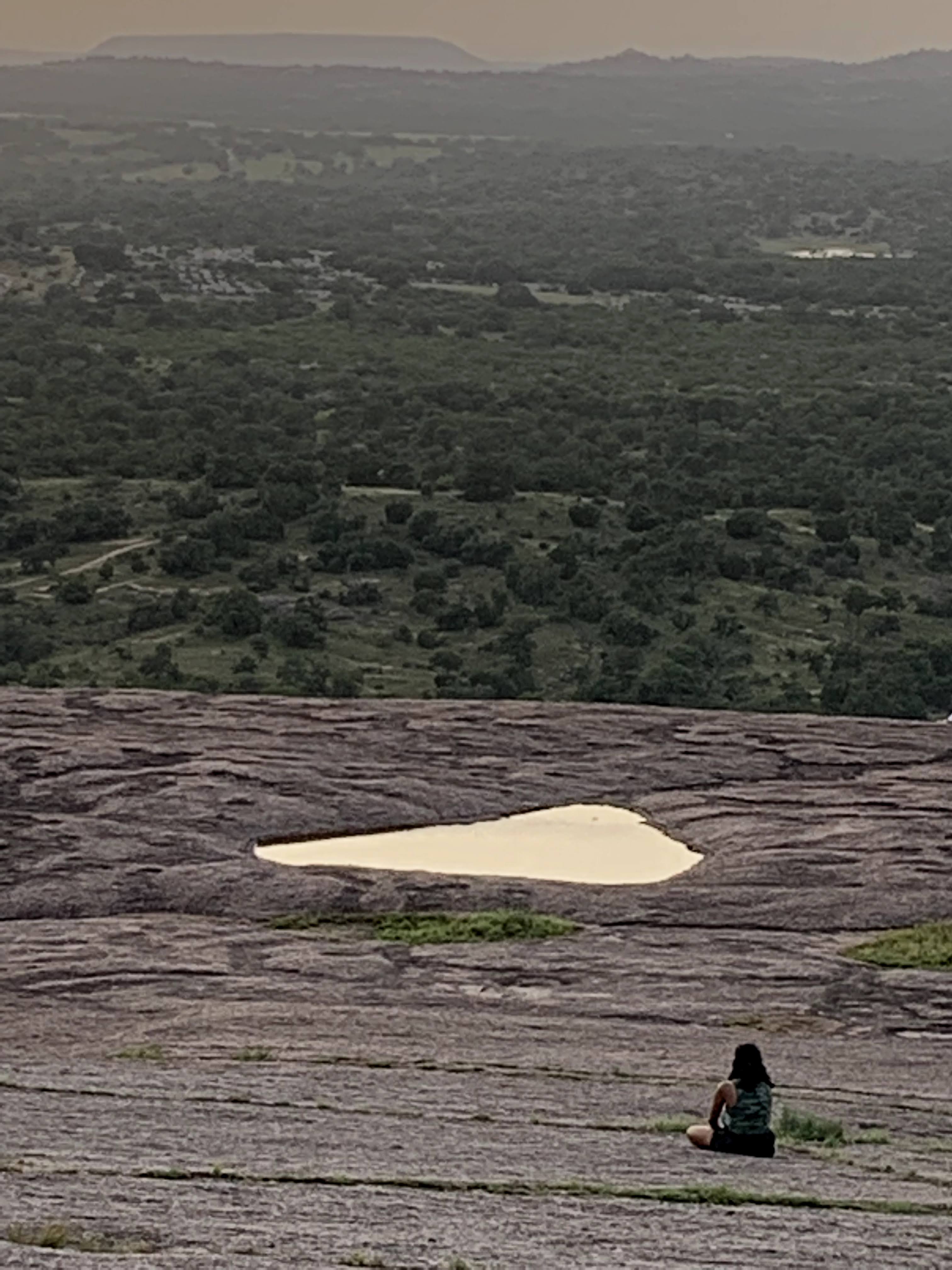 woman sitting on mountain and watching the sunset