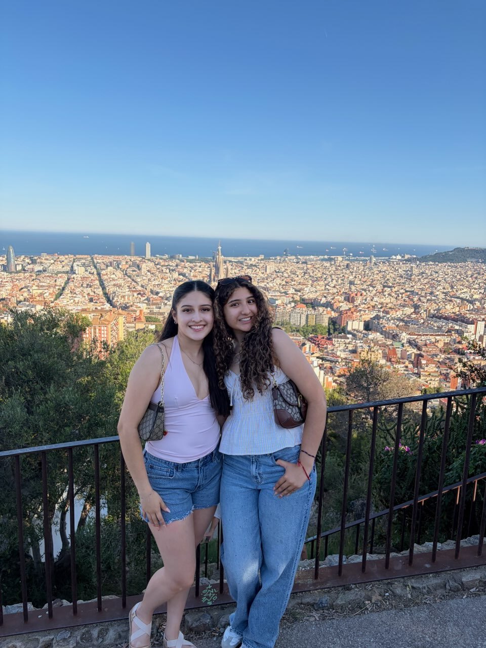A photo of two women with a landscape behind them