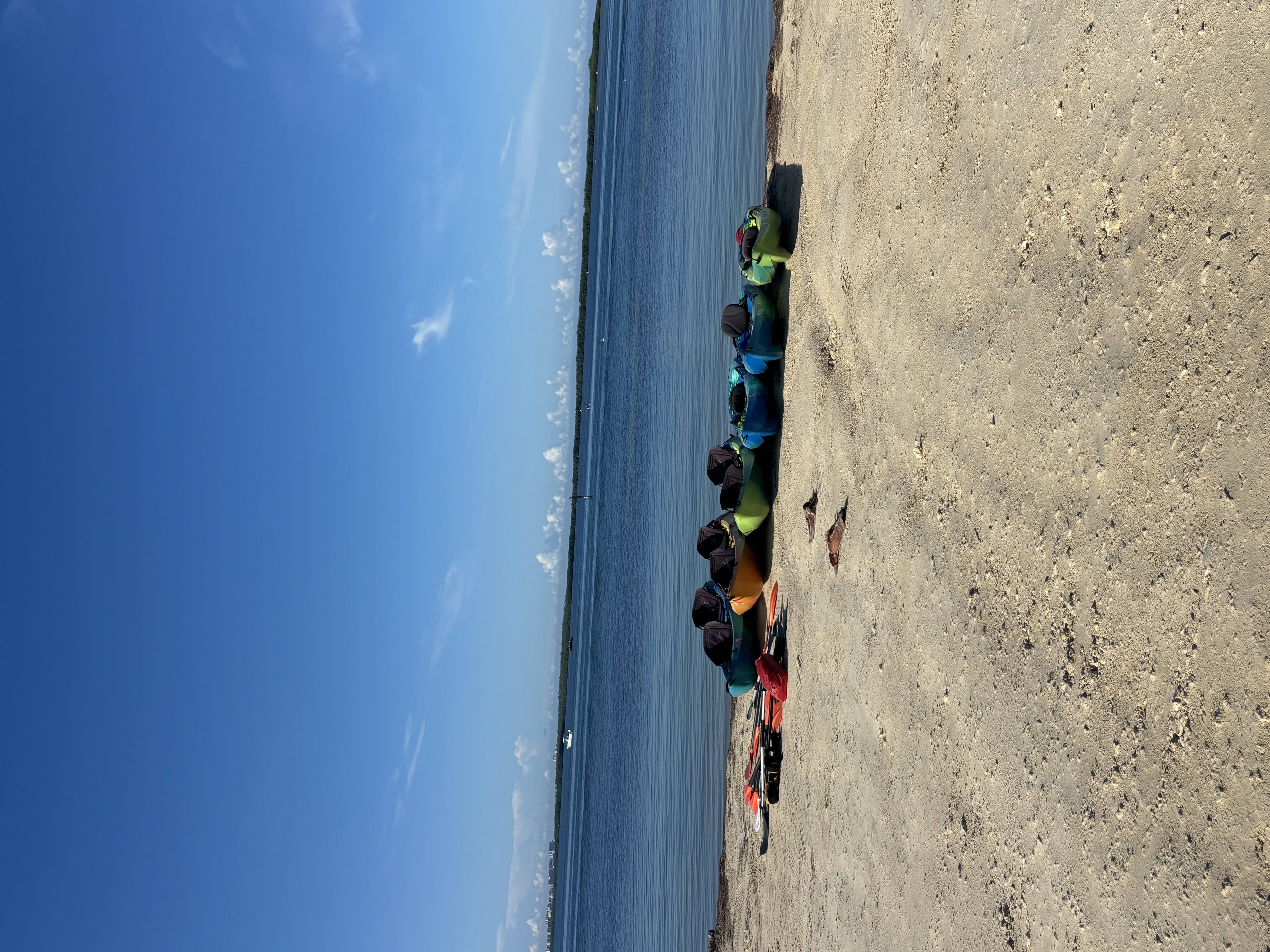 Kayaks lined up on the beach ready to launch.