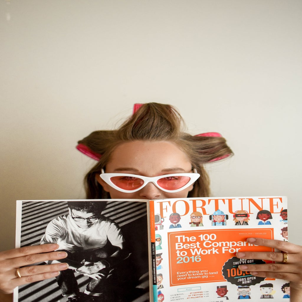 Girl with curlers in reads magazine
