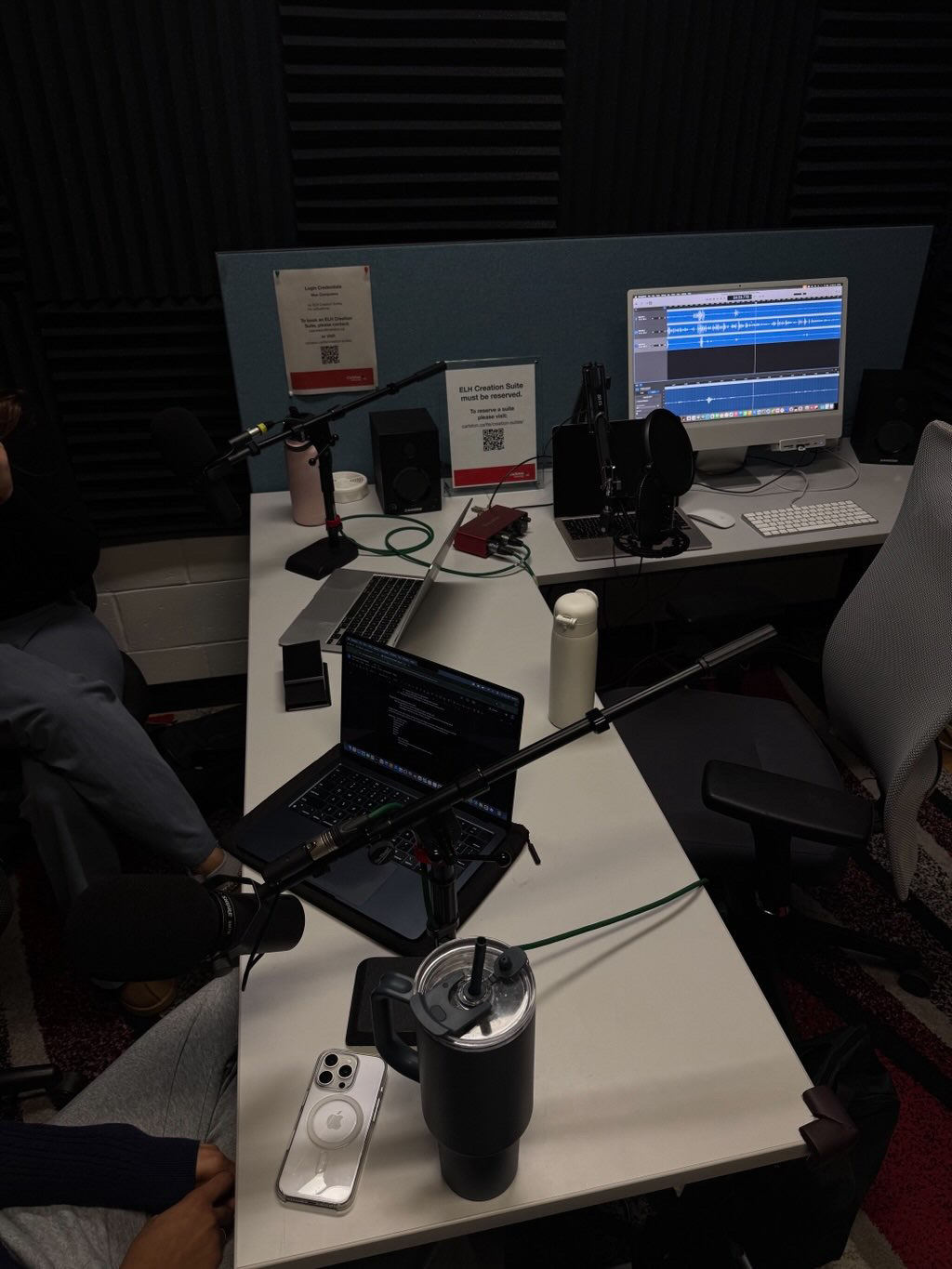 Podcast table featuring audio equipment and editing software.