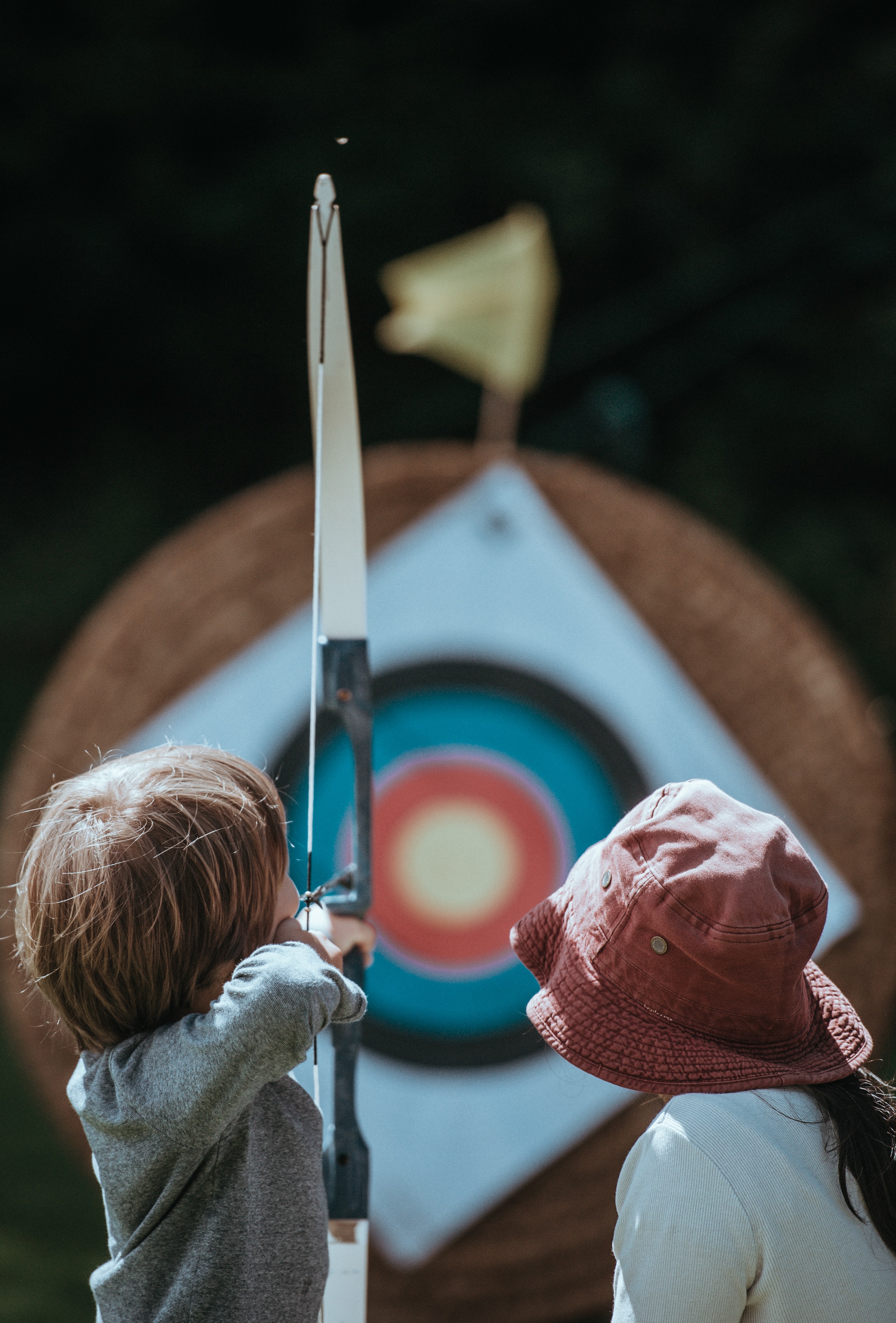 two kids playing with a bow and arrow