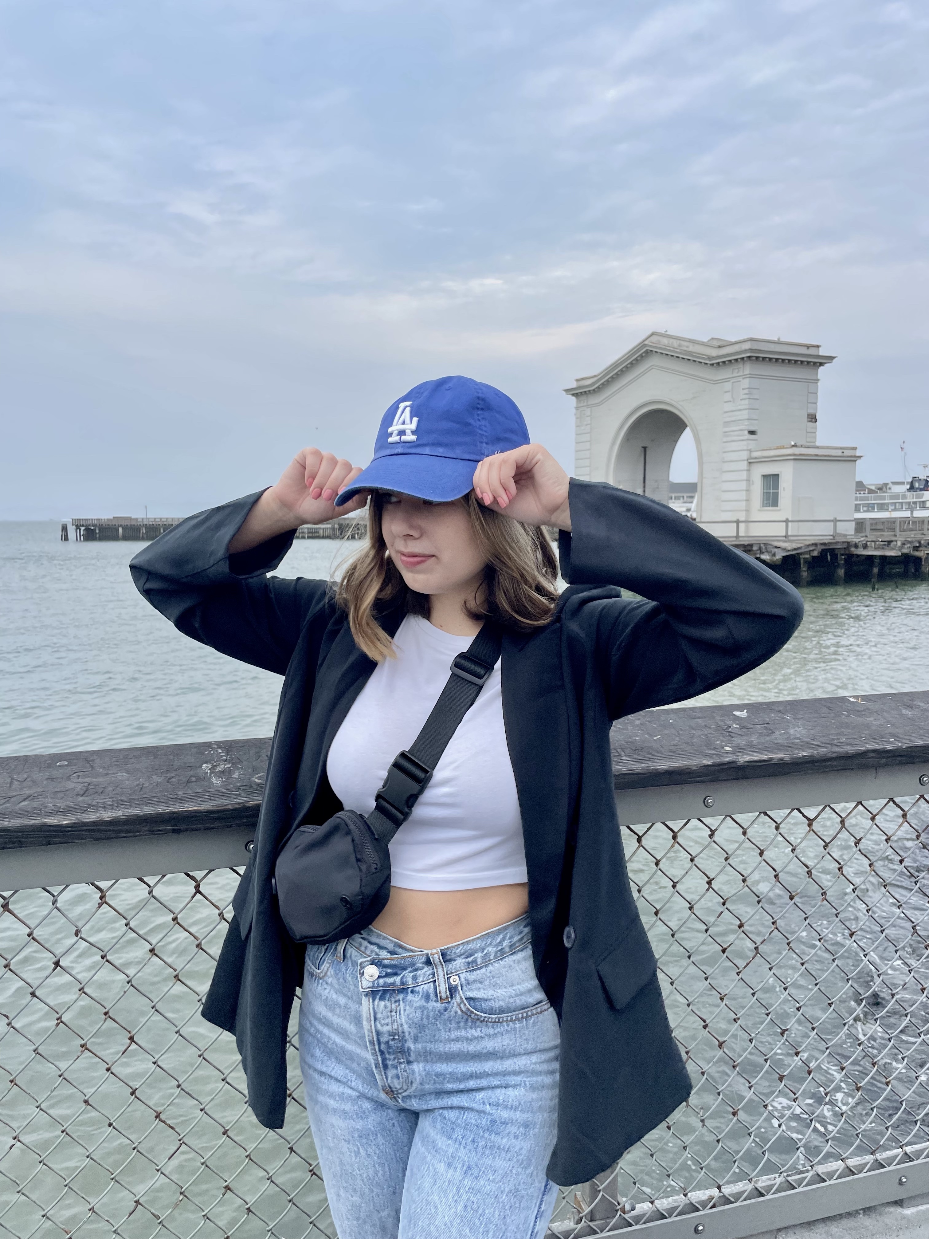 girl wearing black blazer, jeans and a hat